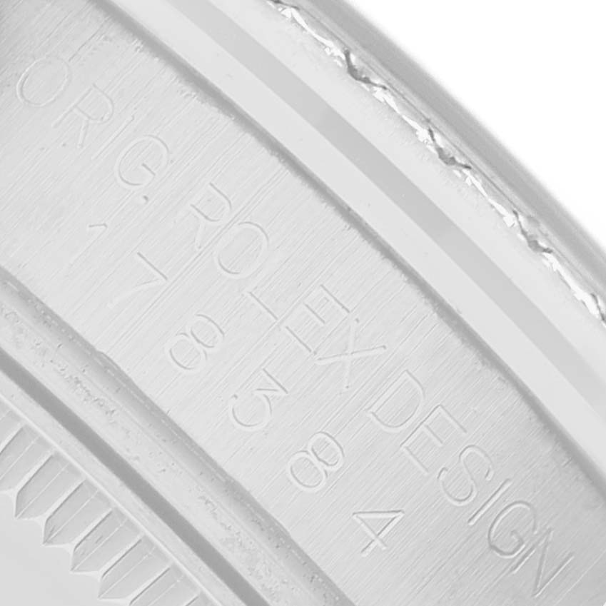 The image shows the engraved inner rim or rehault of a Rolex Datejust 178384 Women's Stainless Steel Blue Dial, focusing on the brand name and design engravings.