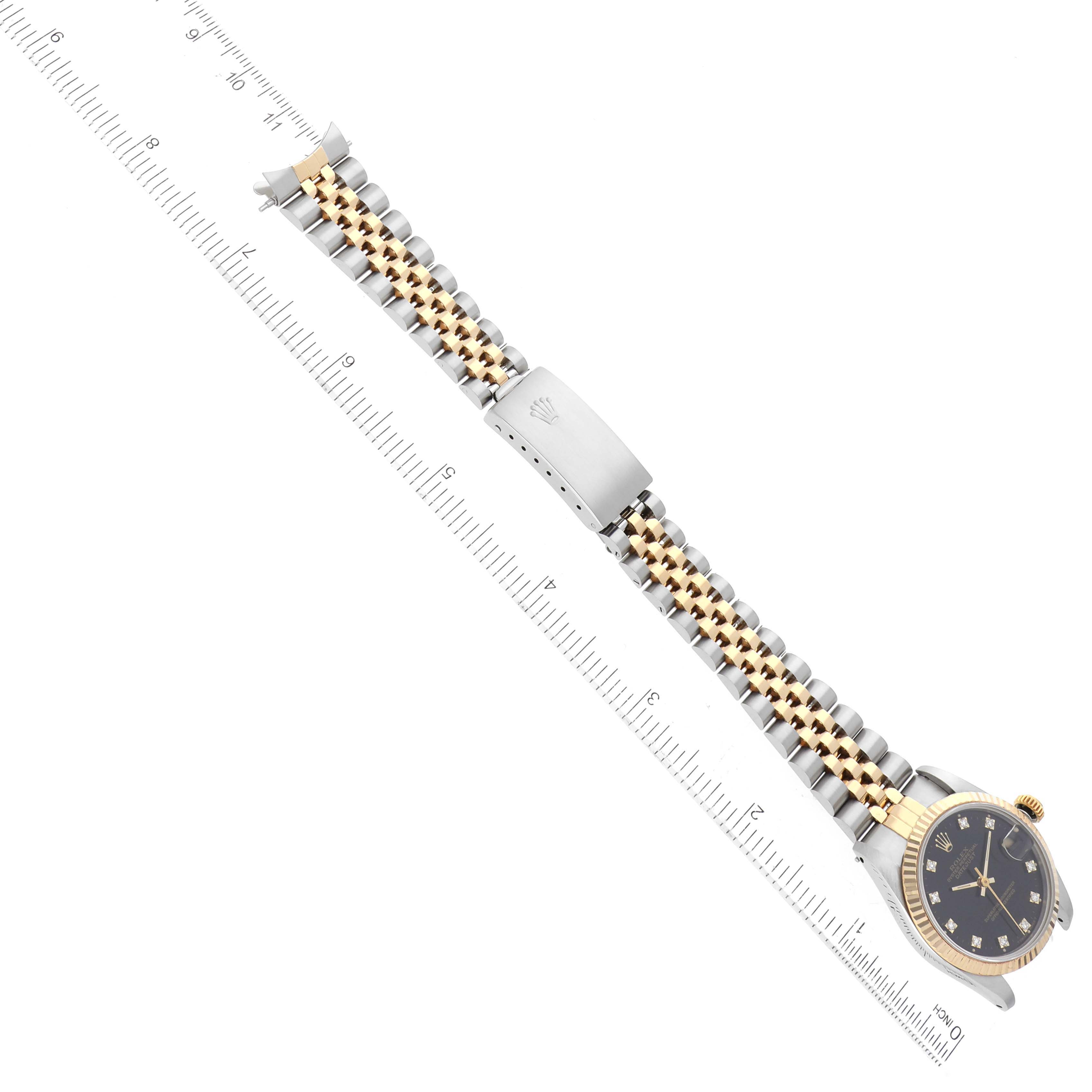 The image shows a Rolex Mid-Size 68273 Women's Steel and Gold (two tone) Black Dial 68273 Women's Steel and Gold (two tone) Black Dial model watch laid flat with a ruler, highlighting the bracelet and watch face.