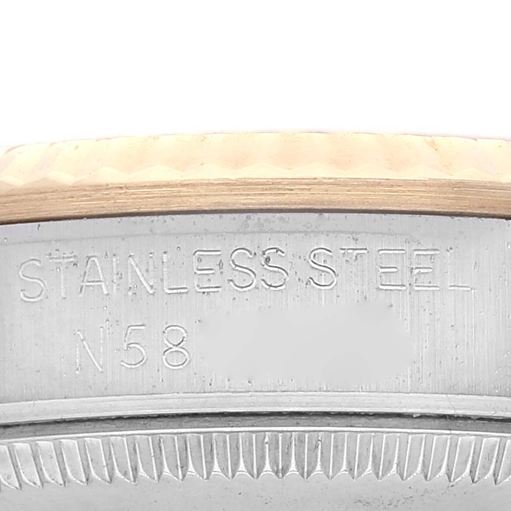 The image shows a close-up view of the case back and bezel edge on a Mid-Size Rolex watch, featuring the "Stainless Steel" engraving.