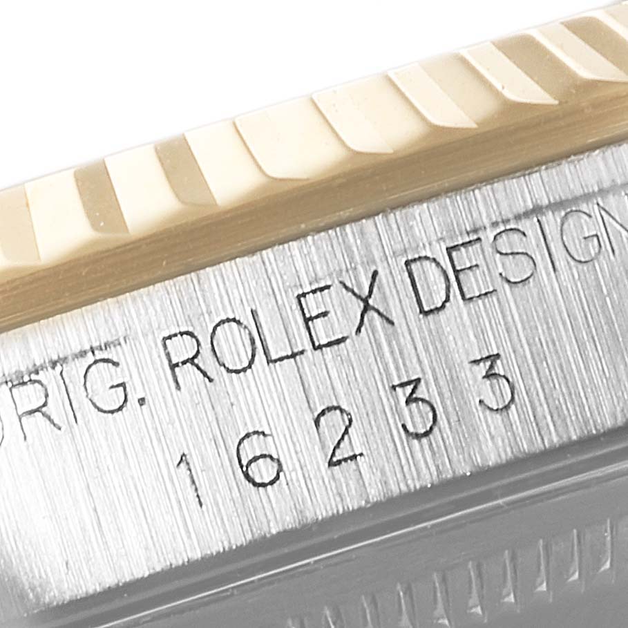 This close-up shows the fluted bezel and model number engraving on the case side of a Rolex Datejust 16233 Men's Steel and Gold (two tone) Blue Dial 16233 Men's Steel and Gold (two tone) Blue Dial.