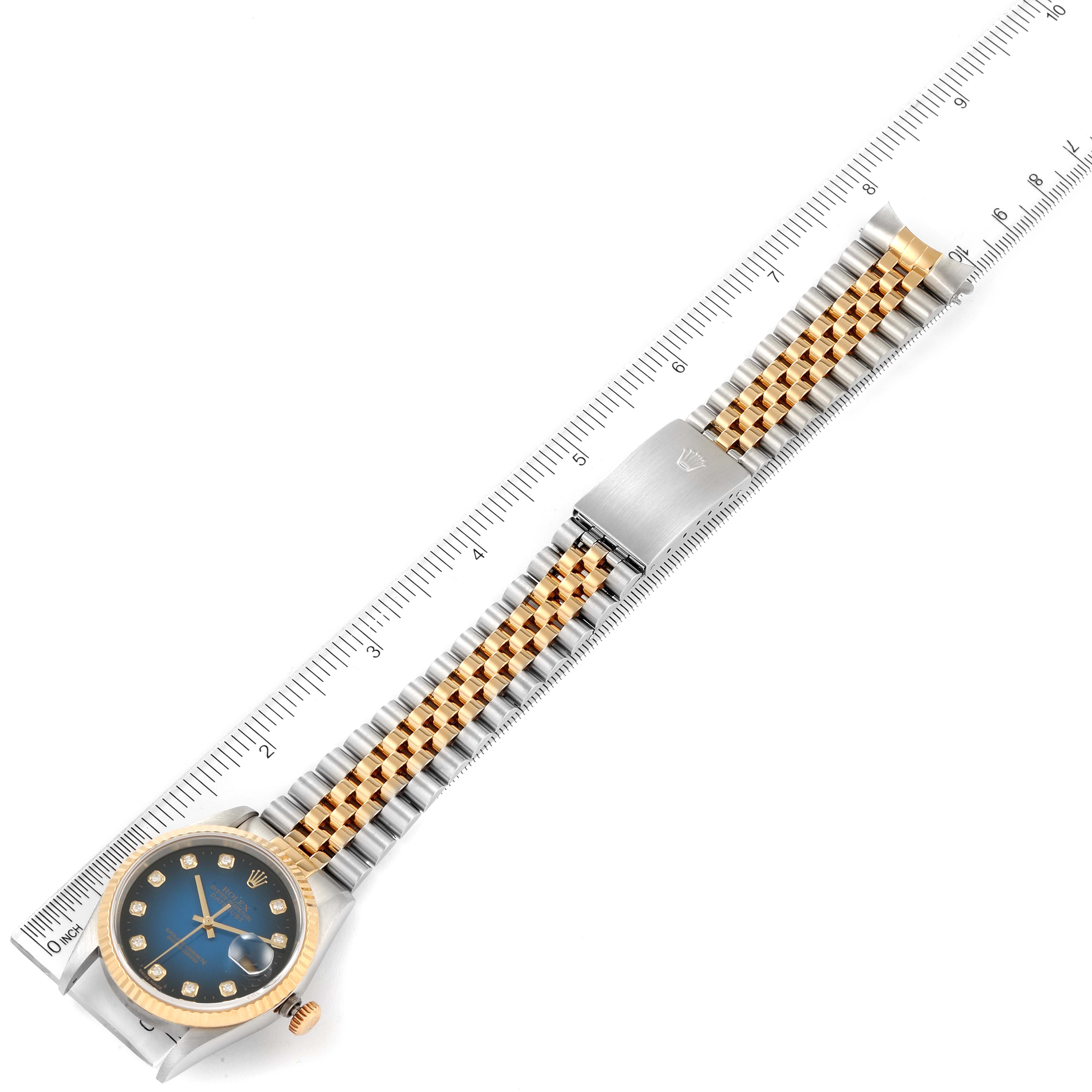 The Rolex Datejust 16233 Men's Steel and Gold (two tone) Blue Dial 16233 Men's Steel and Gold (two tone) Blue Dial watch is shown laid flat with a focus on the face, bracelet, and clasp against a measured ruler.