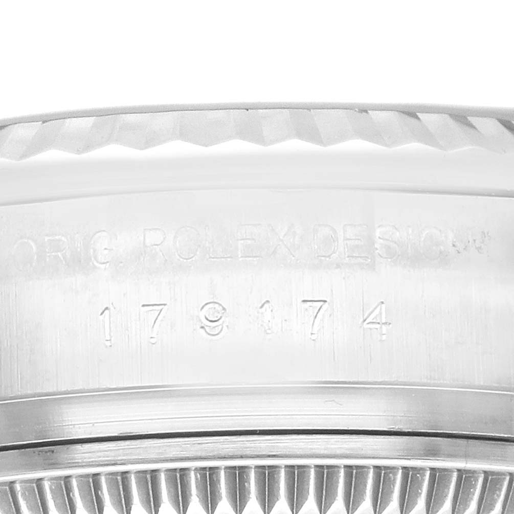 The image shows a close-up of the Rolex Datejust 179174 Women's Stainless Steel Black Dial 179174 Women's Stainless Steel Black Dial model's case, prominently displaying the serial number.
