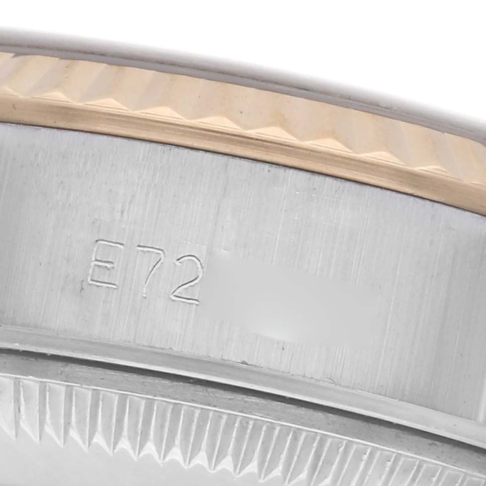 The image shows a close-up of the side of a Rolex Datejust 69173 Women's Steel and Gold (two tone) Blue Dial 69173 Women's Steel and Gold (two tone) Blue Dial, focusing on the fluted bezel and engraved serial number.