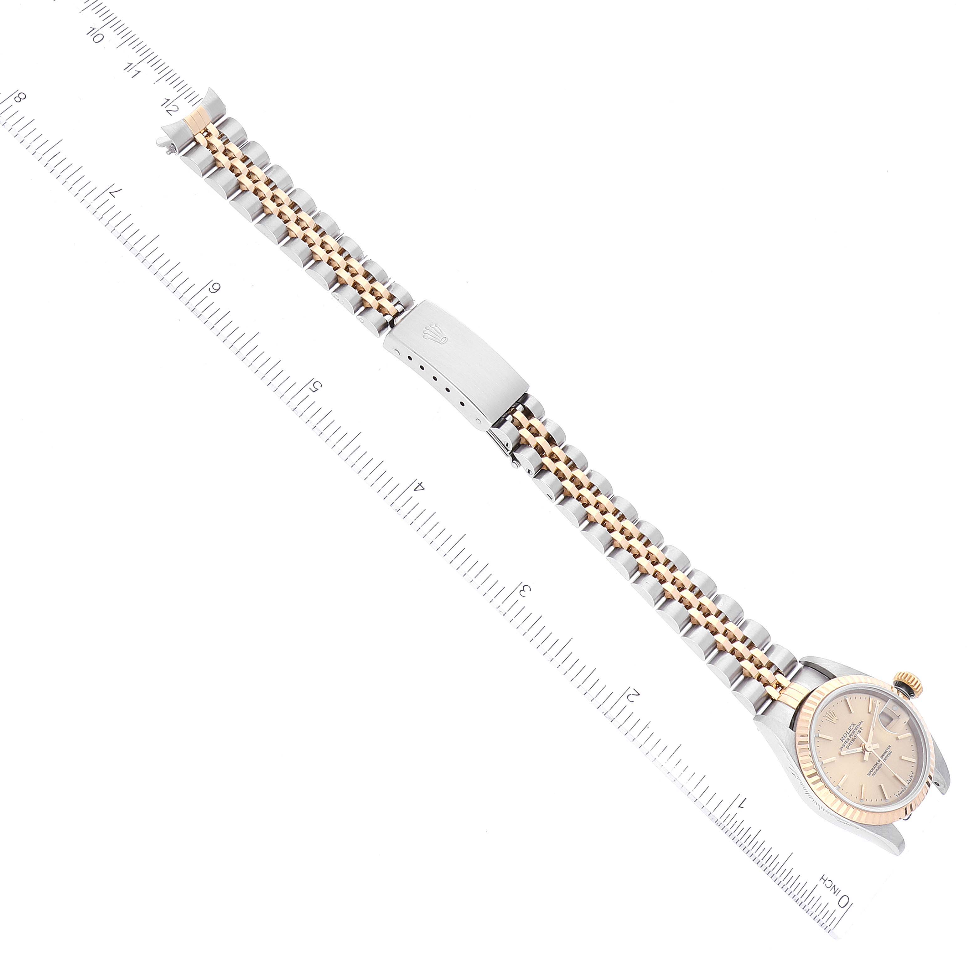 The image shows the Rolex Datejust 79173 Women's Steel and Gold (two tone) Champagne Dial 79173 Women's Steel and Gold (two tone) Champagne Dial watch placed diagonally alongside a measuring ruler, showcasing its bracelet and clasp.