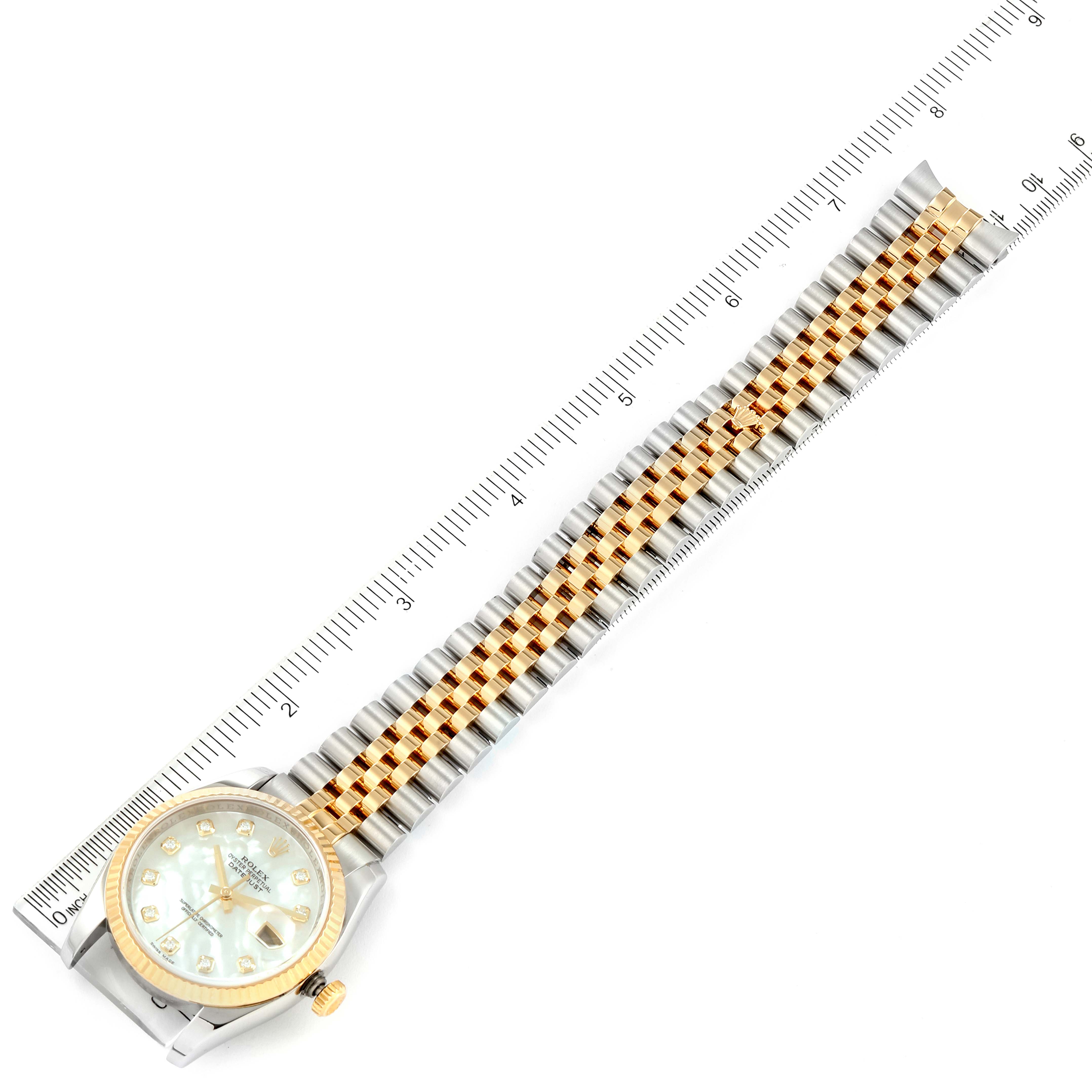 The image shows a Rolex Datejust 116233 Men's Steel and Gold (two tone) Mother of Pearl Dial 116233 Men's Steel and Gold (two tone) Mother of Pearl Dial watch laid flat, displaying its face and bracelet alongside a measurement ruler.