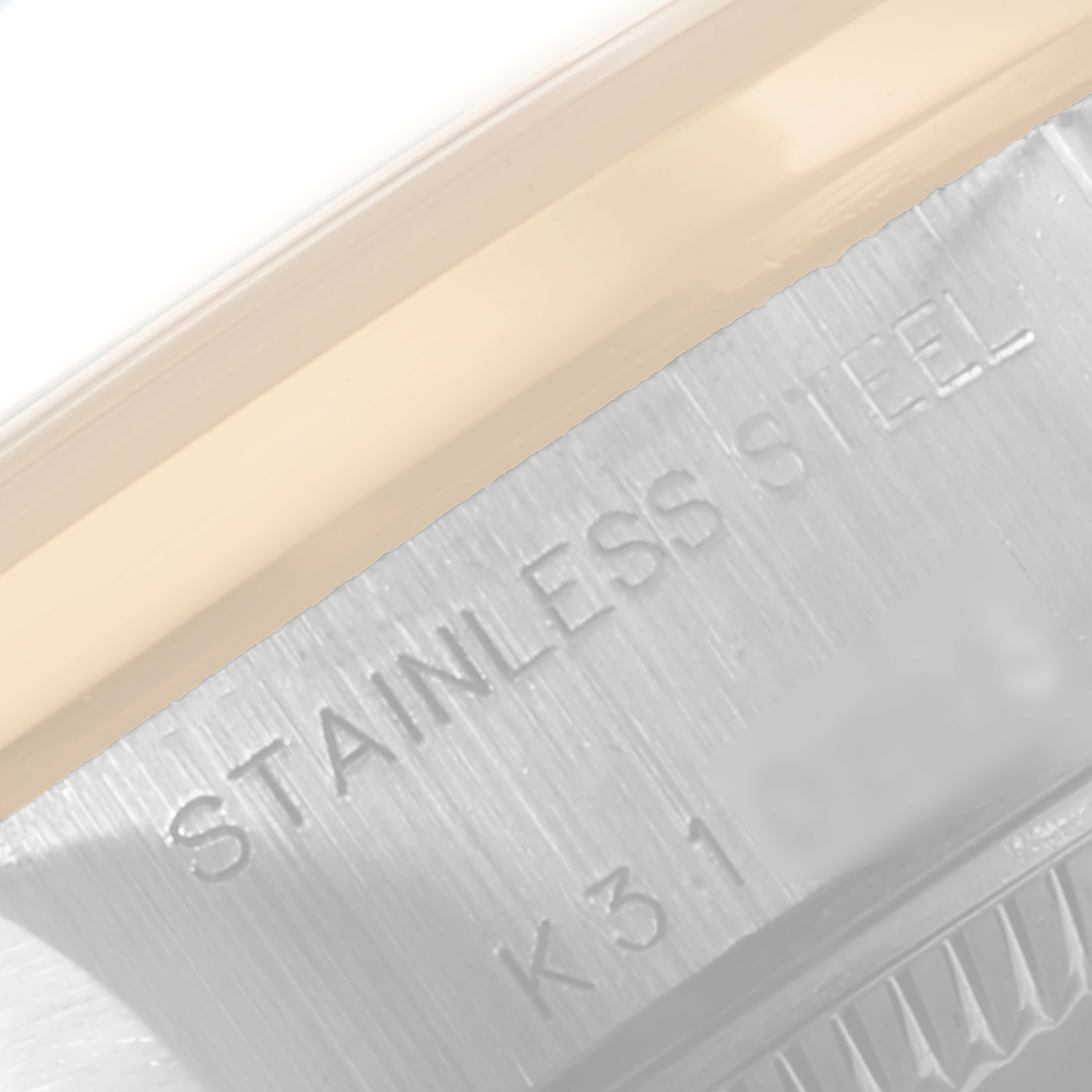 This image shows a close-up of a part of the Rolex Datejust 79163 Women's Steel and Gold (two tone) Silver Dial 79163 Women's Steel and Gold (two tone) Silver Dial watch case, displaying the "STAINLESS STEEL" engraving.