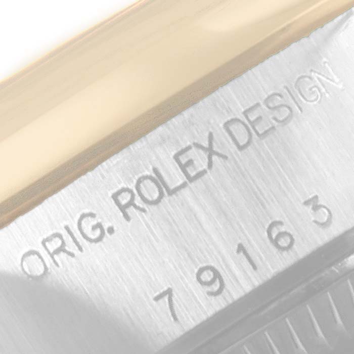 A close-up angle of a Rolex Datejust 79163 Women's Steel and Gold (two tone) Silver Dial 79163 Women's Steel and Gold (two tone) Silver Dial model shows part of the case with "ORIG. ROLEX DESIGN" engraved.