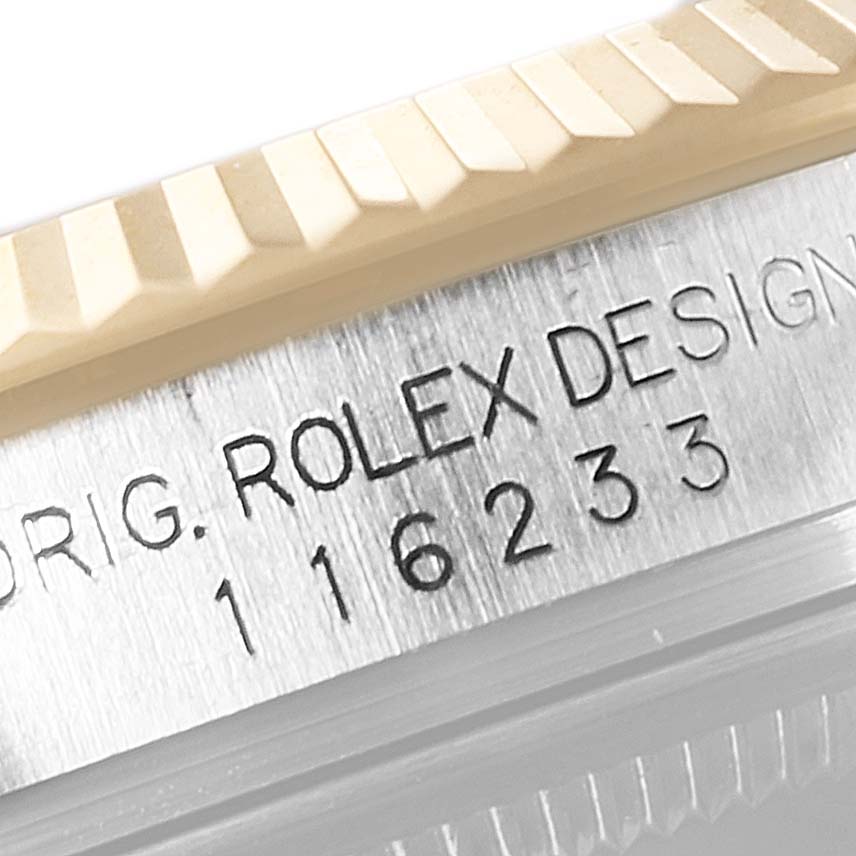 The image shows a close-up of the serial number engraving and fluted bezel edge of a Rolex Datejust 116233 Men's Steel and Gold (two tone) Silver Dial 116233 Men's Steel and Gold (two tone) Silver Dial watch.