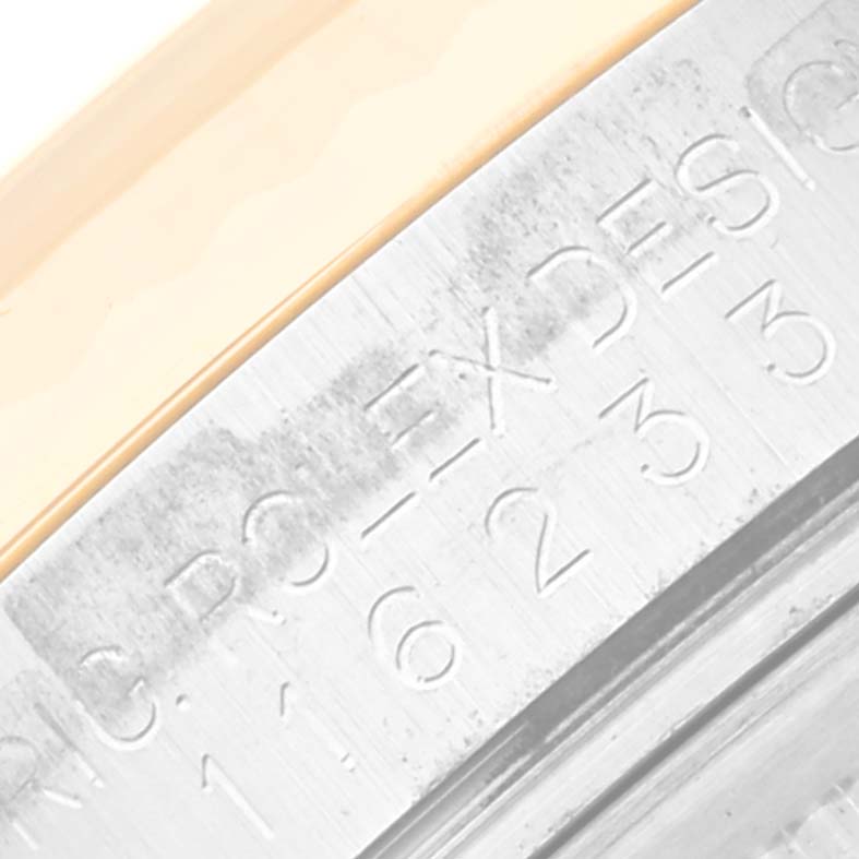 The image shows a close-up of the engraved rehaut of a Rolex Datejust 116233 Men's Steel and Gold (two tone) White Dial 116233 Men's Steel and Gold (two tone) White Dial watch, highlighting part of the bezel and case.