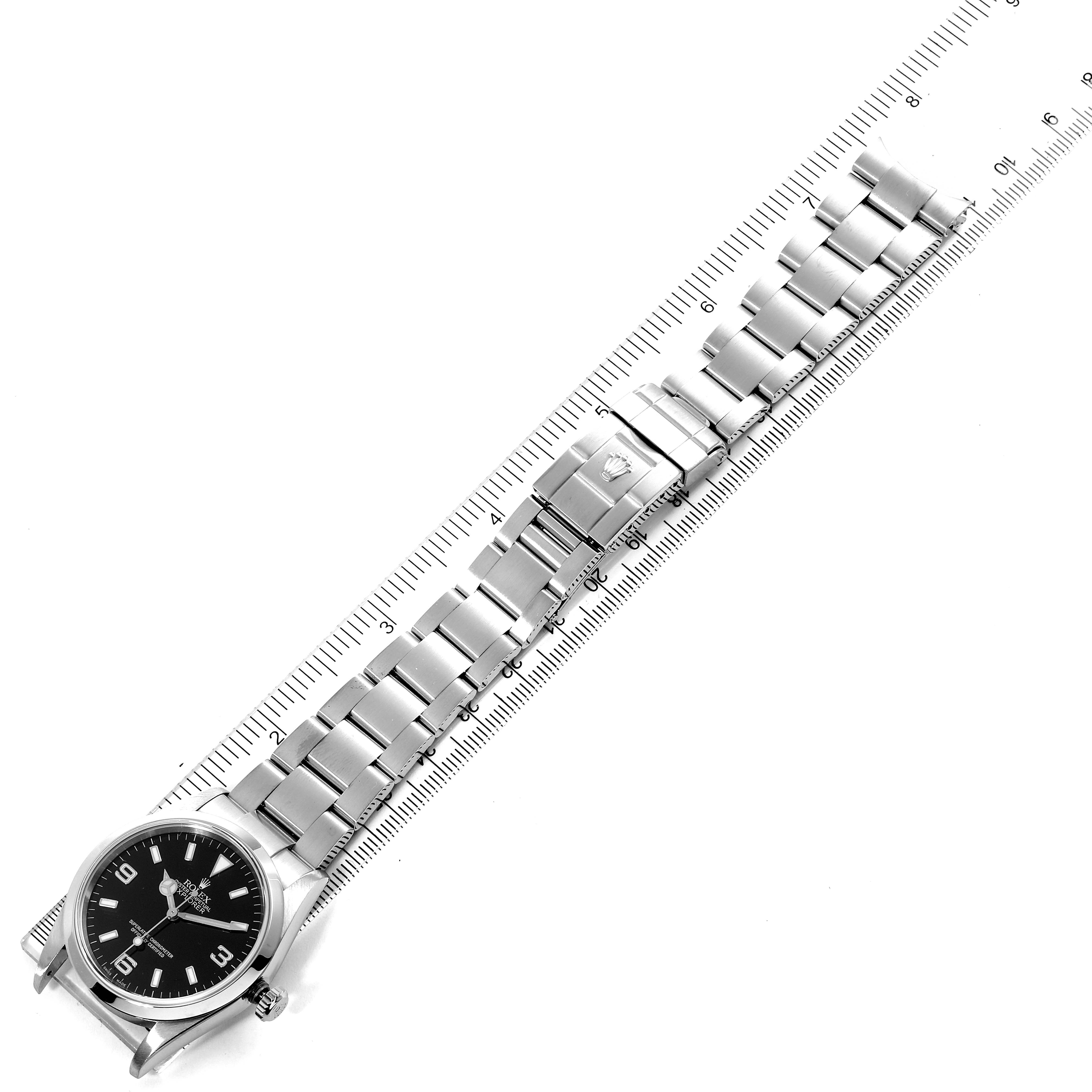 The image shows a Rolex Explorer 114270 Men's Stainless Steel Black Dial 114270 Men's Stainless Steel Black Dial watch lying flat, highlighting the face and the metal bracelet, measured against a ruler.