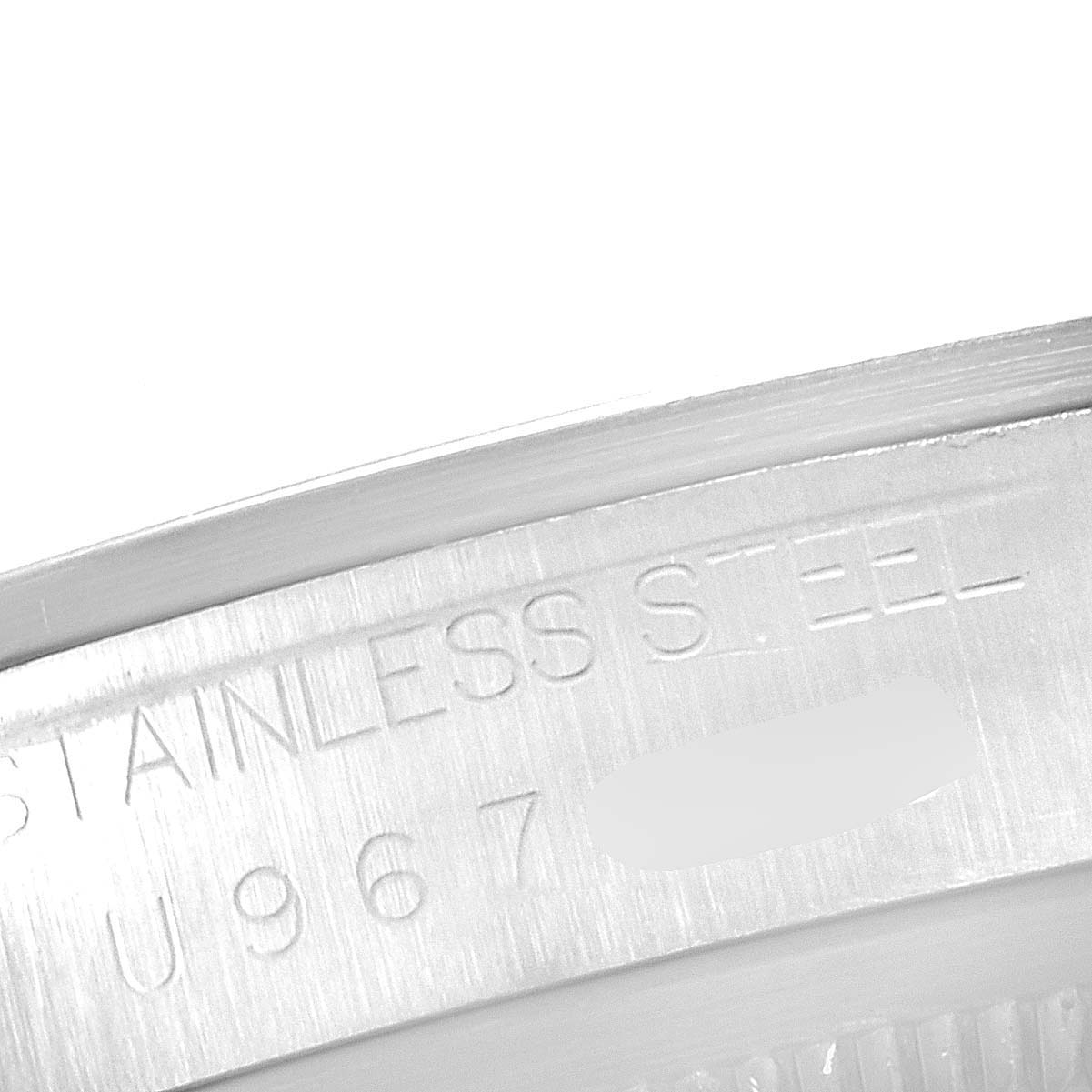 The image shows a close-up of the side of a Rolex Explorer 14270 Men
s Stainless Steel Black Dial 14270 Men
s Stainless Steel Black Dial watch, focusing on the engraved serial number and "STAINLESS STEEL" text.