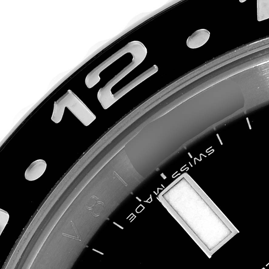 This image shows a close-up of the bezel and part of the dial of a Rolex GMT-Master 116710 Men
s Stainless Steel Black Dial 116710 Men
s Stainless Steel Black Dial watch.