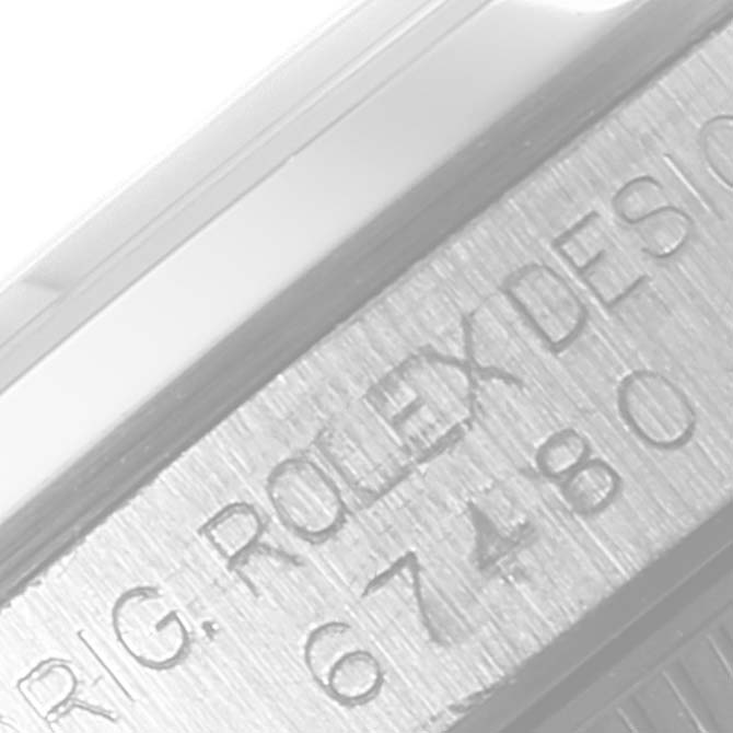 This image shows a close-up of the serial number and engraving on the side of a Rolex Mid-Size 67480 Women's Stainless Steel Blue Dial 67480 Women's Stainless Steel Blue Dial model watch case.