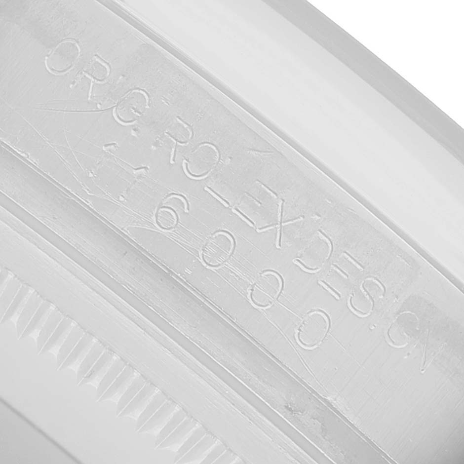 The image shows a close-up of the engraving on the inner bezel ring of a Rolex Oyster Perpetual 116000 Men's Stainless Steel Silver Dial watch.