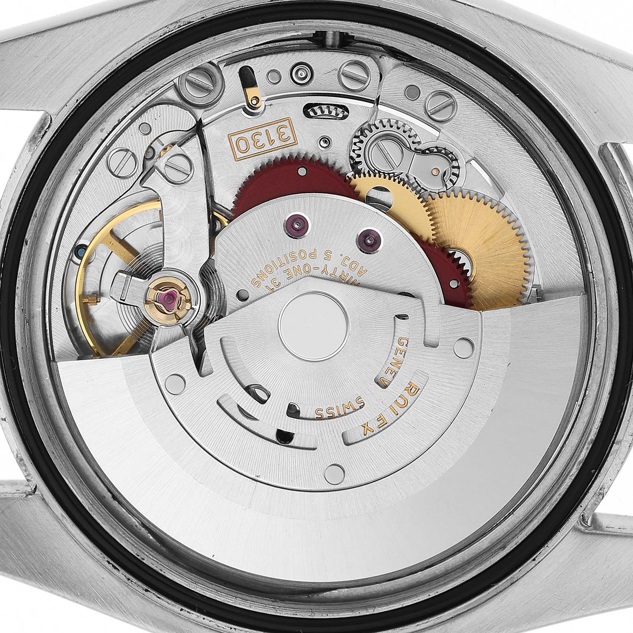 The image shows the movement of a Rolex Oyster Perpetual 116000 Men's Stainless Steel Silver Dial watch from a top-down view, highlighting gears and the rotor.