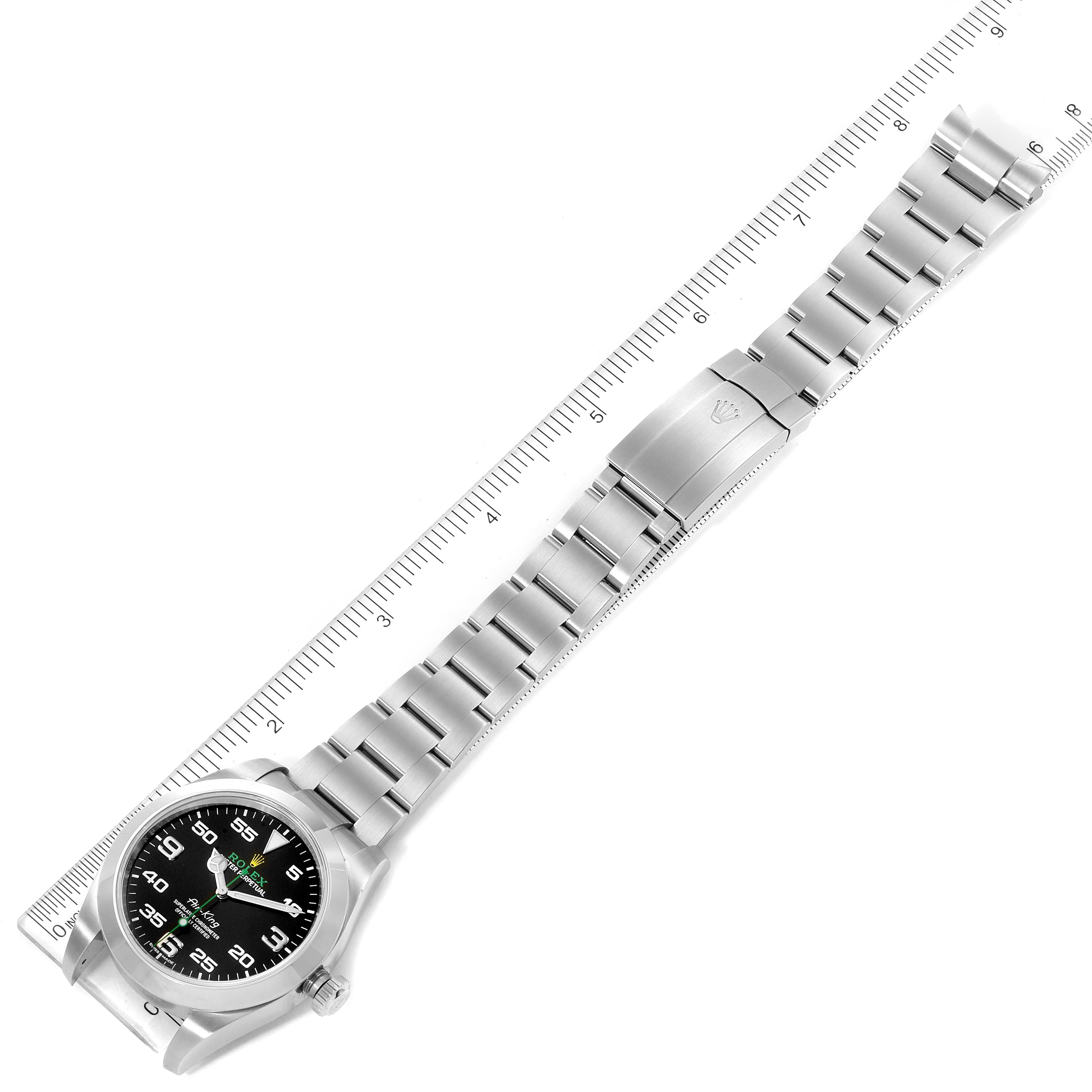 The image shows the Rolex Air-King 116900 Men's Stainless Steel Black Dial 116900 Men's Stainless Steel Black Dial watch laid flat against a ruler, displaying its entire band and face from a top-down angle.
