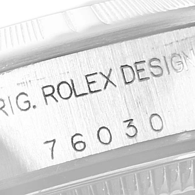 The image shows a close-up of the case side of an Oyster Perpetual Rolex watch, highlighting the engraved model number and "ROLEX DESIGN" text.