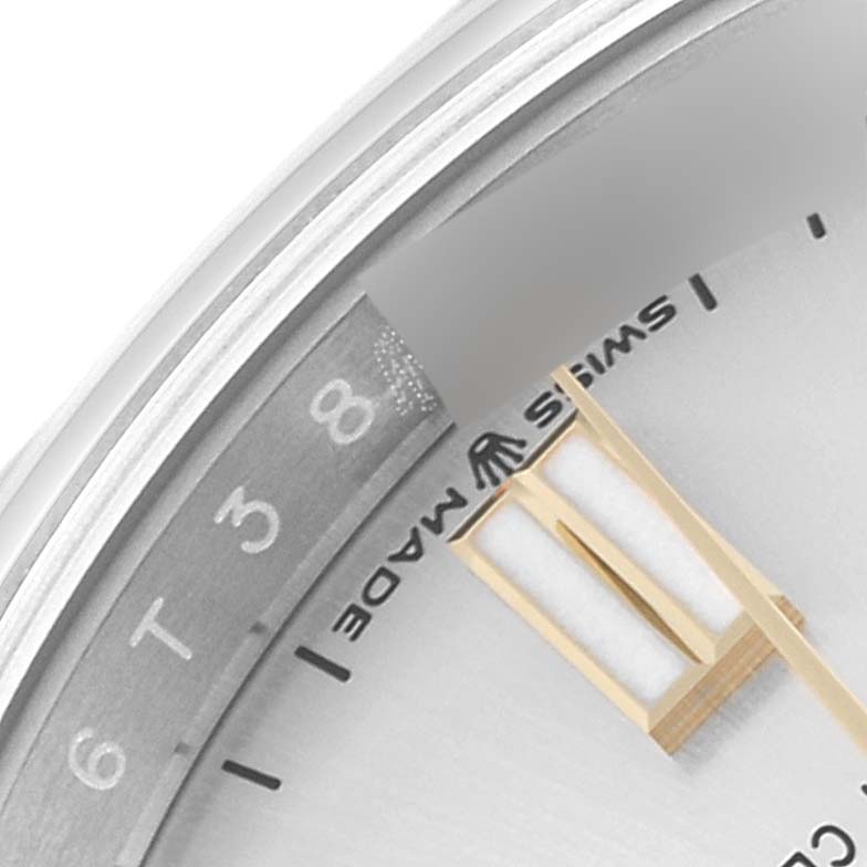 This close-up image of a Rolex Oyster Perpetual 126000 Men's Stainless Steel Silver Dial 126000 Men's Stainless Steel Silver Dial watch shows the dial's edge, part of the bezel, and a section of the minute hand.