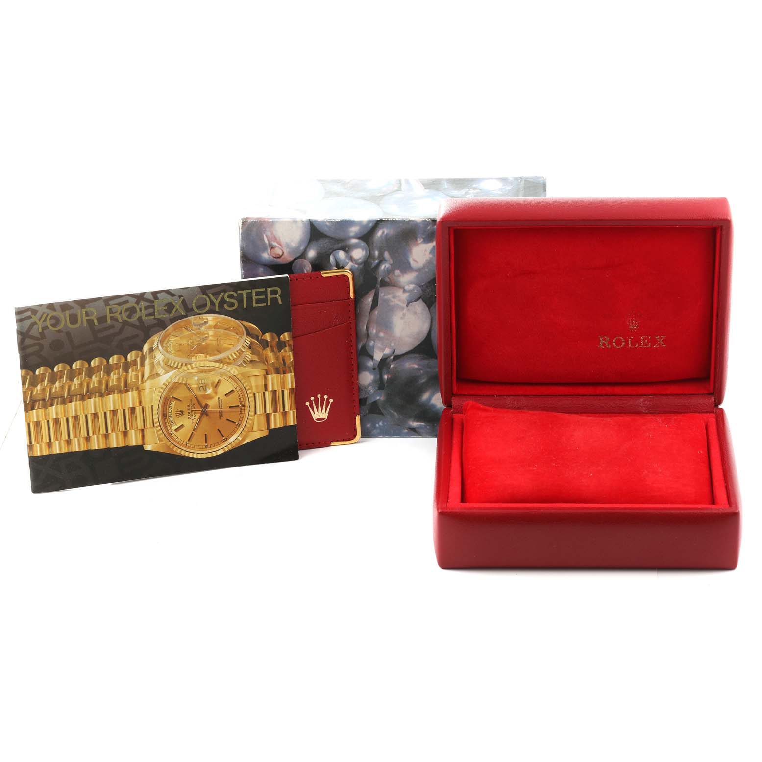 The image shows a red Rolex box, booklets, and accessories for the President model by Rolex, displayed from a front angle.