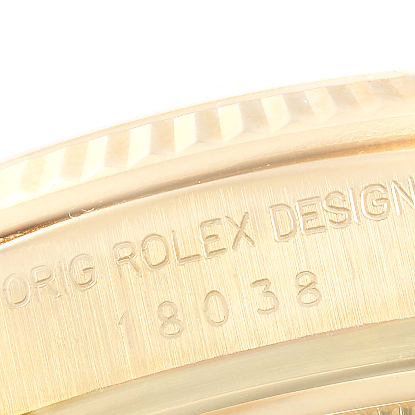 This close-up image of a Rolex President 18038 Men's Yellow Gold Silver Dial 18038 Men's Yellow Gold Silver Dial model watch shows the edge of the bezel and engraved case details.