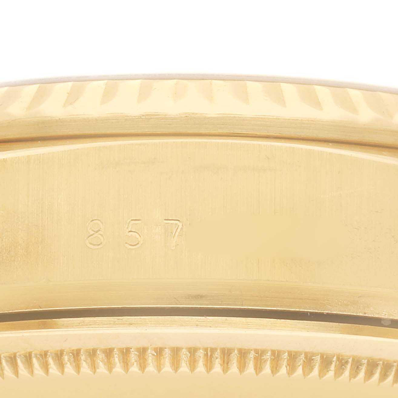 The image shows a close-up of the side of the Rolex President 18038 Men
s Yellow Gold Champagne Dial 18038 Men
s Yellow Gold Champagne Dial watch case, highlighting its fluted bezel and part of the engraved serial number.