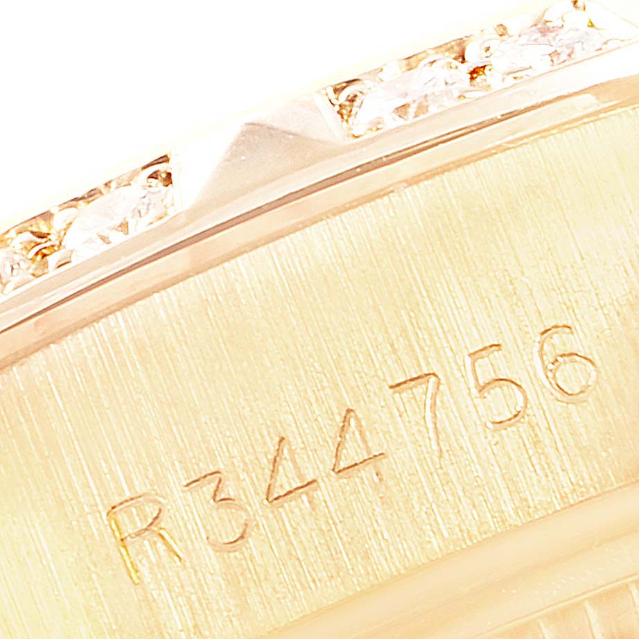 Close-up of the Rolex Pearlmaster 69258 Women's Yellow Gold Champagne Dial 69258 Women's Yellow Gold Champagne Dial watch, showing part of the bezel and a serial number engraved on the case.