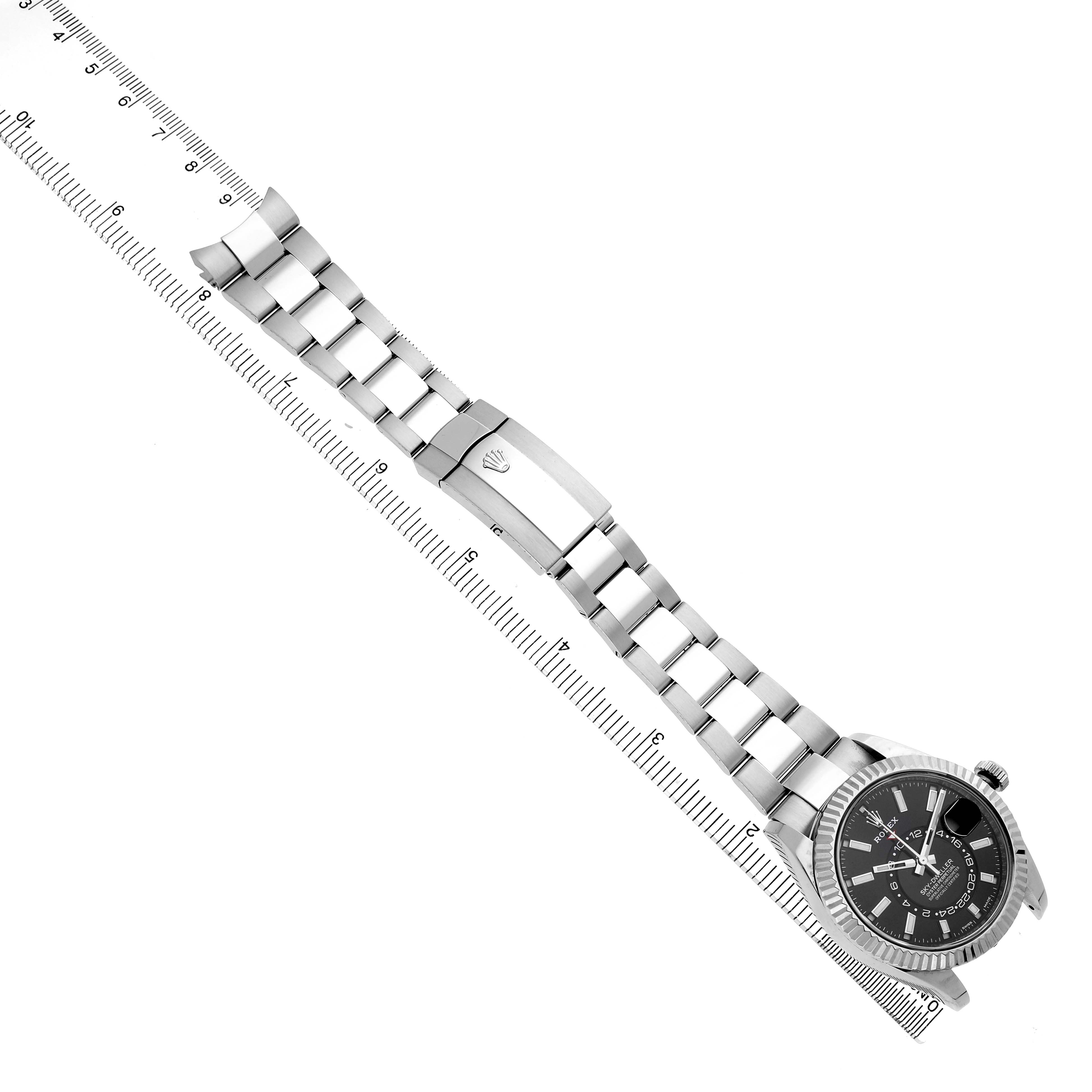 The Rolex Sky-Dweller 326934 Men's Stainless Steel Black Dial watch is shown diagonally from the front, displaying the face, case, and entire bracelet laid out with a ruler.