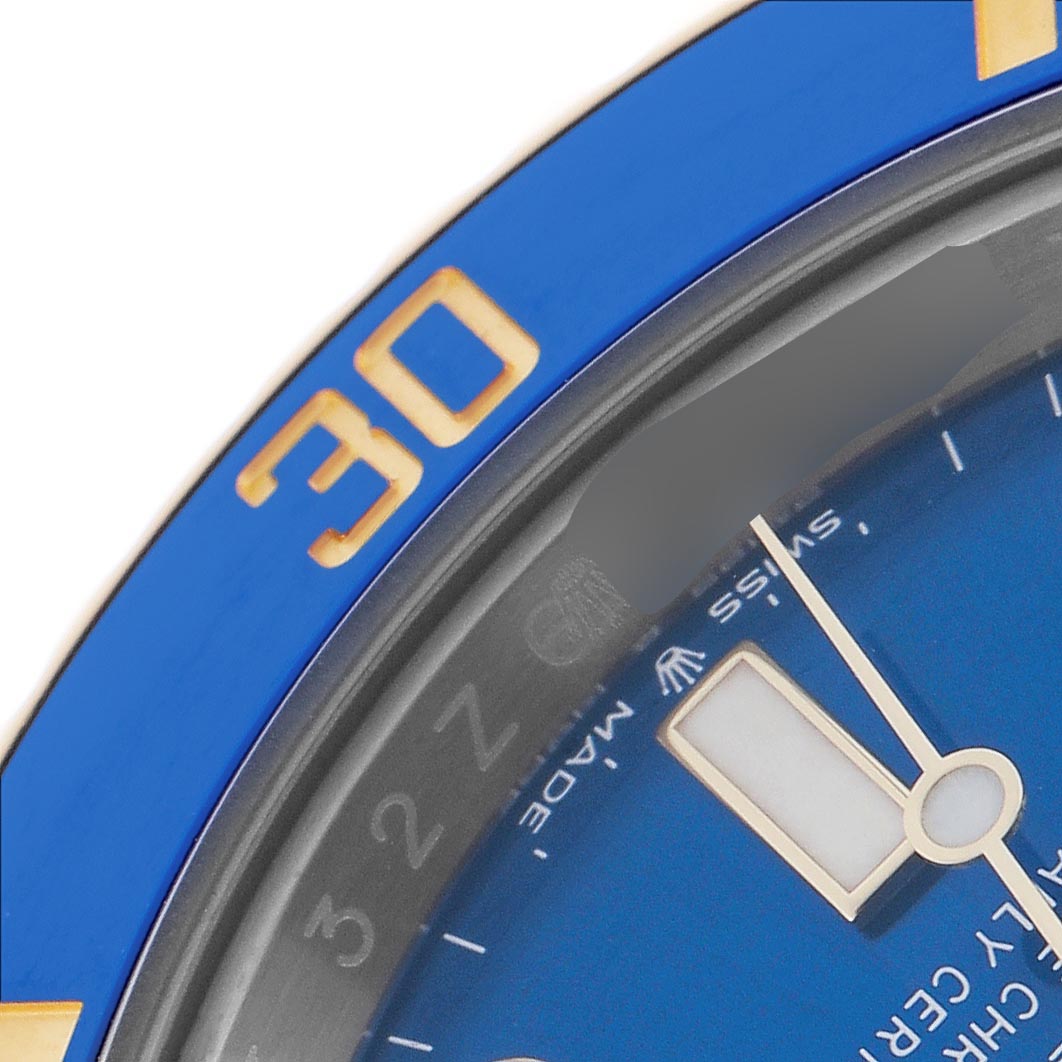 The image shows a close-up of the blue bezel, minute hand, and part of the dial on a Rolex Submariner 126613 Men
s Steel and Gold (two tone) Blue Dial 126613 Men
s Steel and Gold (two tone) Blue Dial watch.