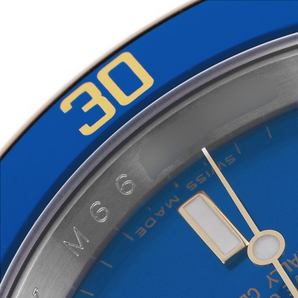 The image shows a close-up of the Rolex Submariner 16613 Men
s Steel and Gold (two tone) Blue Dial 16613 Men
s Steel and Gold (two tone) Blue Dial
s blue bezel, a part of the blue dial, and part of the minute hand.