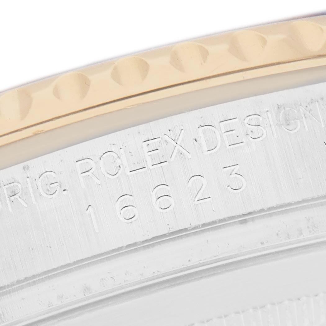 The image shows a close-up of the side of a Rolex Yacht-Master 16623 Men
s Steel and Gold (two tone) Blue Dial 16623 Men
s Steel and Gold (two tone) Blue Dial watch bezel with engraved details.