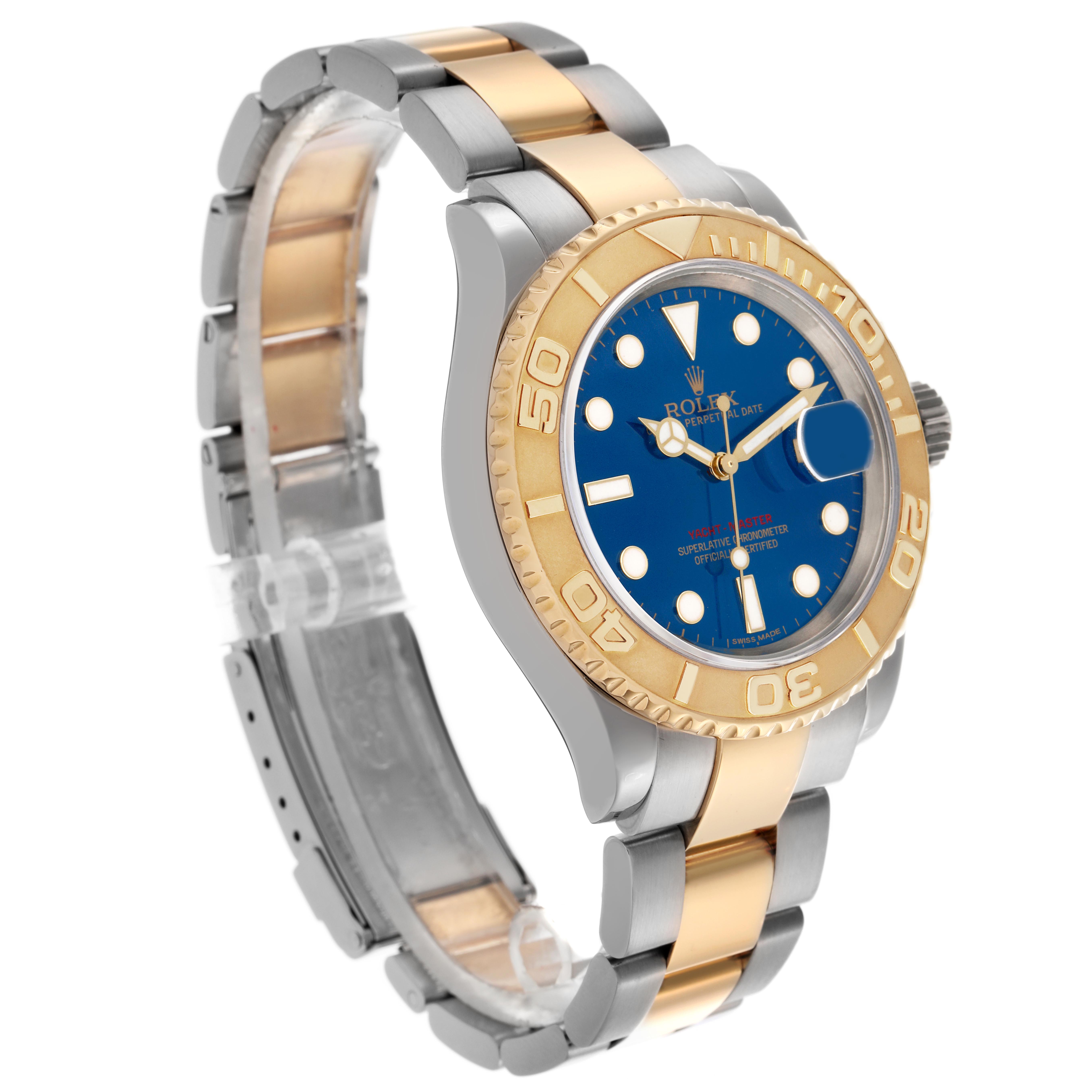 The Rolex Yacht-Master 16623 Men
s Steel and Gold (two tone) Blue Dial 16623 Men
s Steel and Gold (two tone) Blue Dial is shown at a three-quarter angle, highlighting its two-tone bracelet and blue dial with a gold bezel.