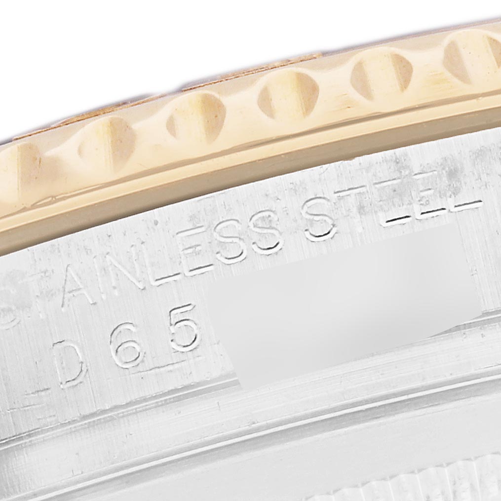 The image shows a close-up of a Rolex Yacht-Master 16623 Men
s Steel and Gold (two tone) Blue Dial 16623 Men
s Steel and Gold (two tone) Blue Dial watch
s bezel and engraved serial number, viewed from the side.