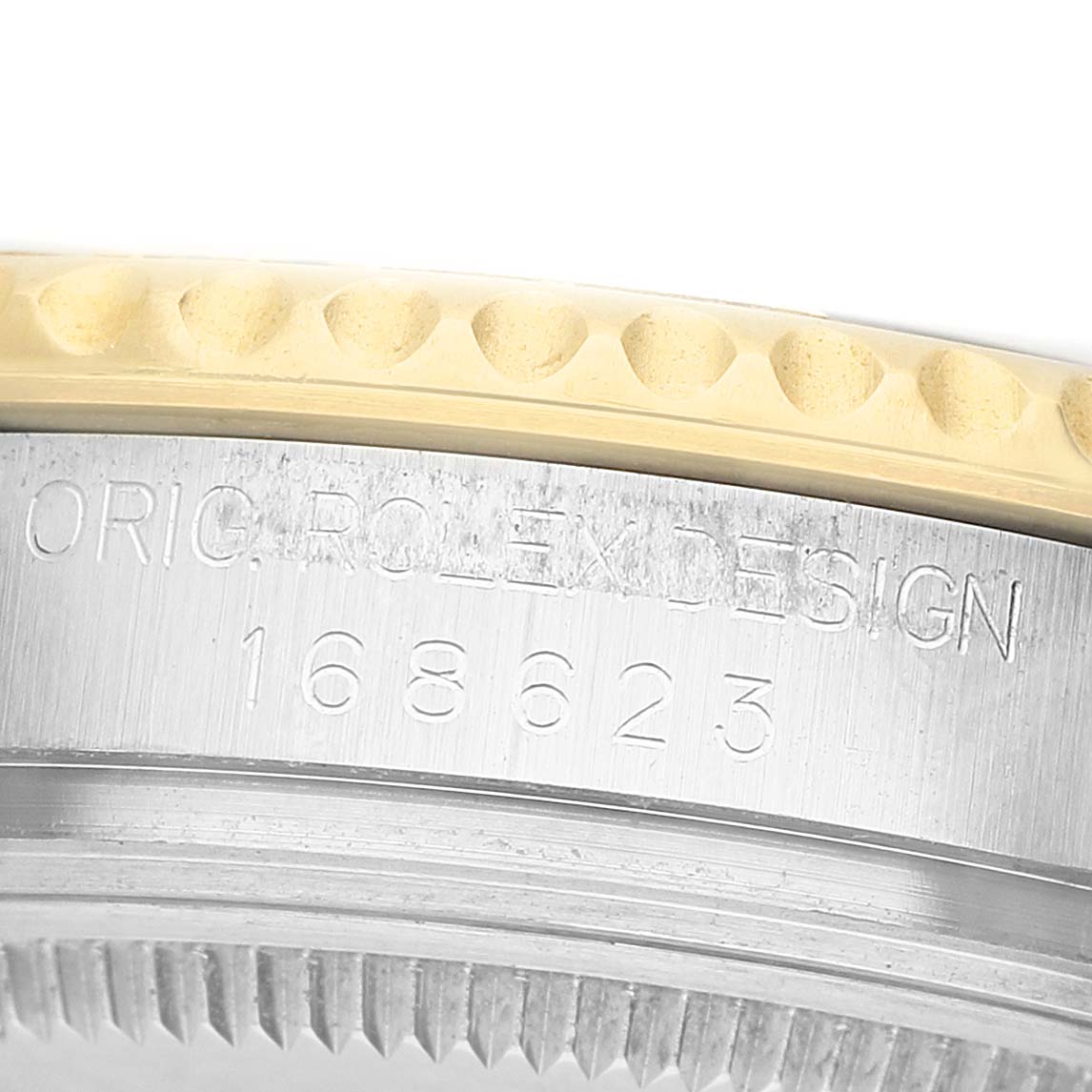 The image shows a close-up of the side of a Rolex Yacht-Master 168623 Men's Steel and Gold (two tone) Champagne Dial watch case with engraved model details.