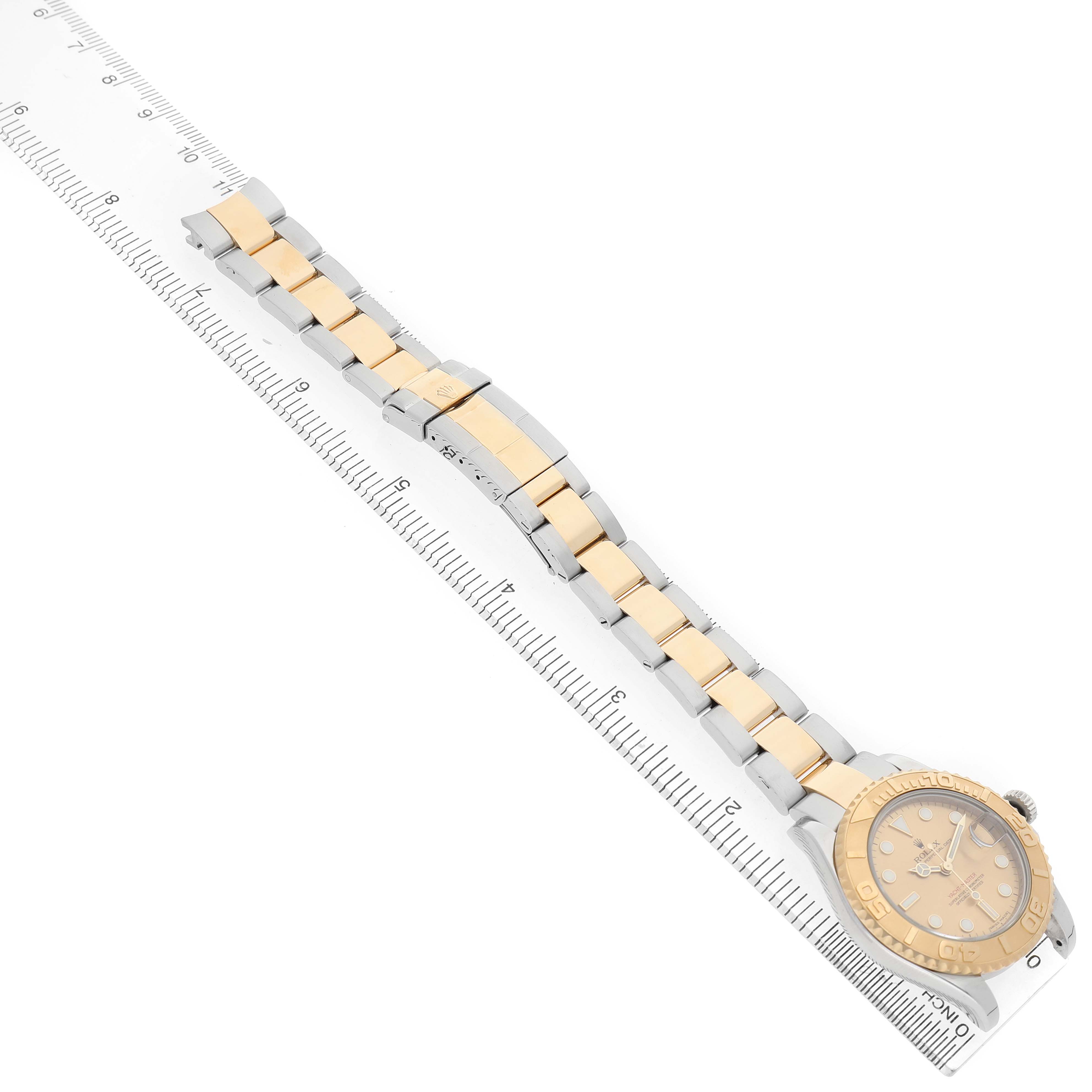 The Rolex Yacht-Master 168623 Men's Steel and Gold (two tone) Champagne Dial watch is shown from a top-down angle, displaying the face, bezel, and two-tone bracelet with a ruler for scale.