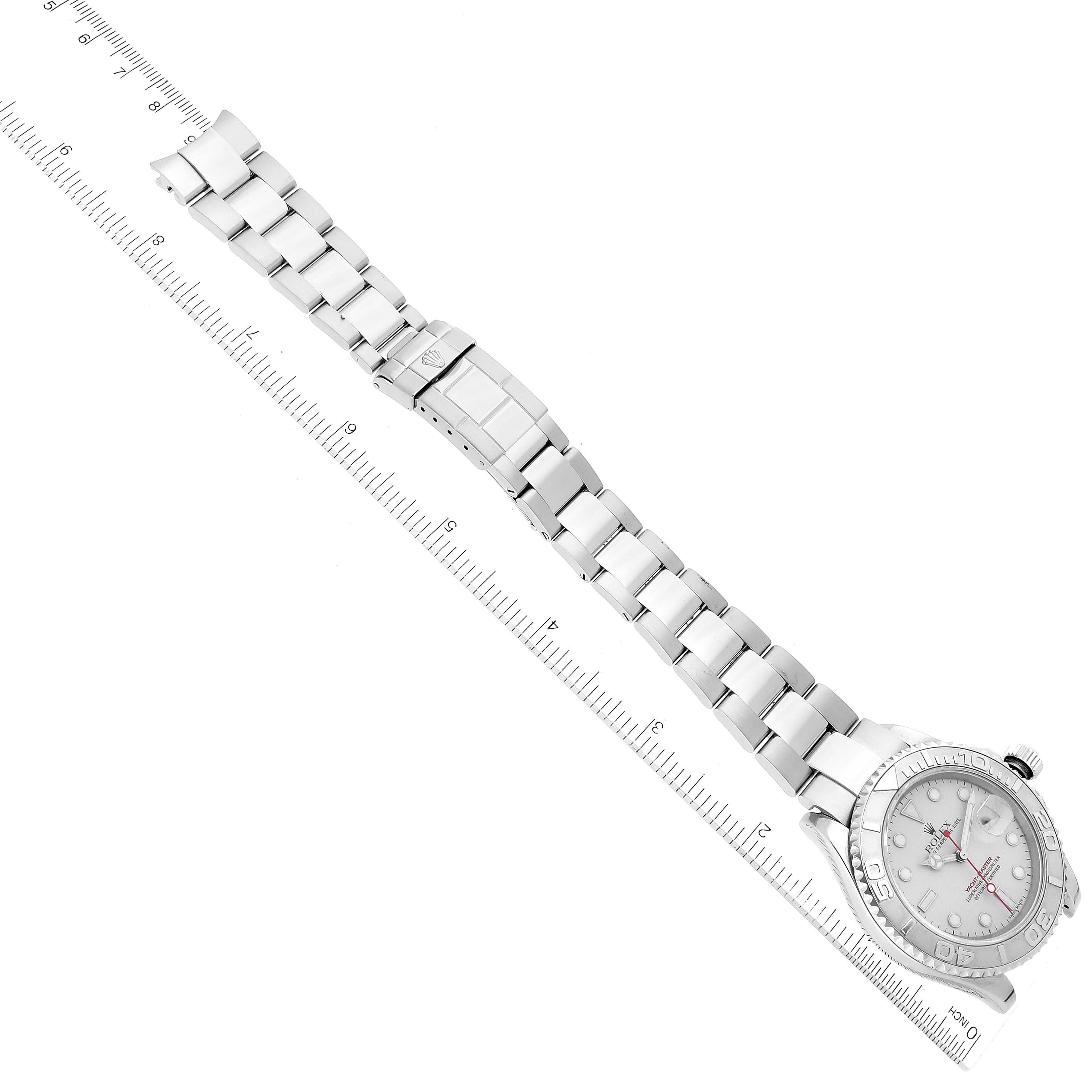 The image shows an overhead view of a Rolex Yacht-Master 16622 Men's Stainless Steel Silver Dial 16622 Men's Stainless Steel Silver Dial watch, displaying its face and entire metal bracelet alongside a measuring ruler.