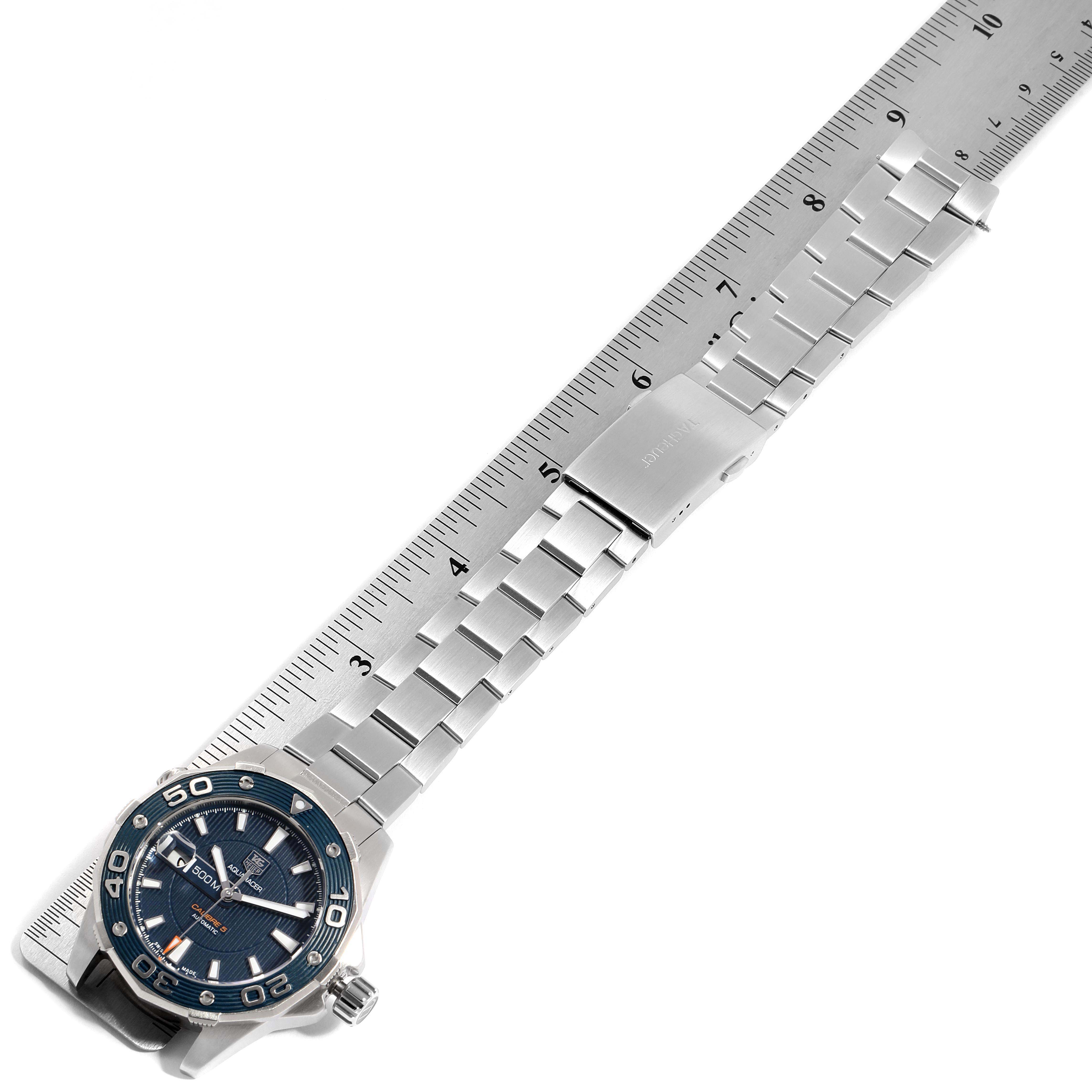 The image shows a Tag Heuer Aquaracer WAJ2112 Men's Stainless Steel Blue Dial WAJ2112 Men's Stainless Steel Blue Dial watch positioned diagonally with its stainless steel bracelet extended and a ruler alongside.