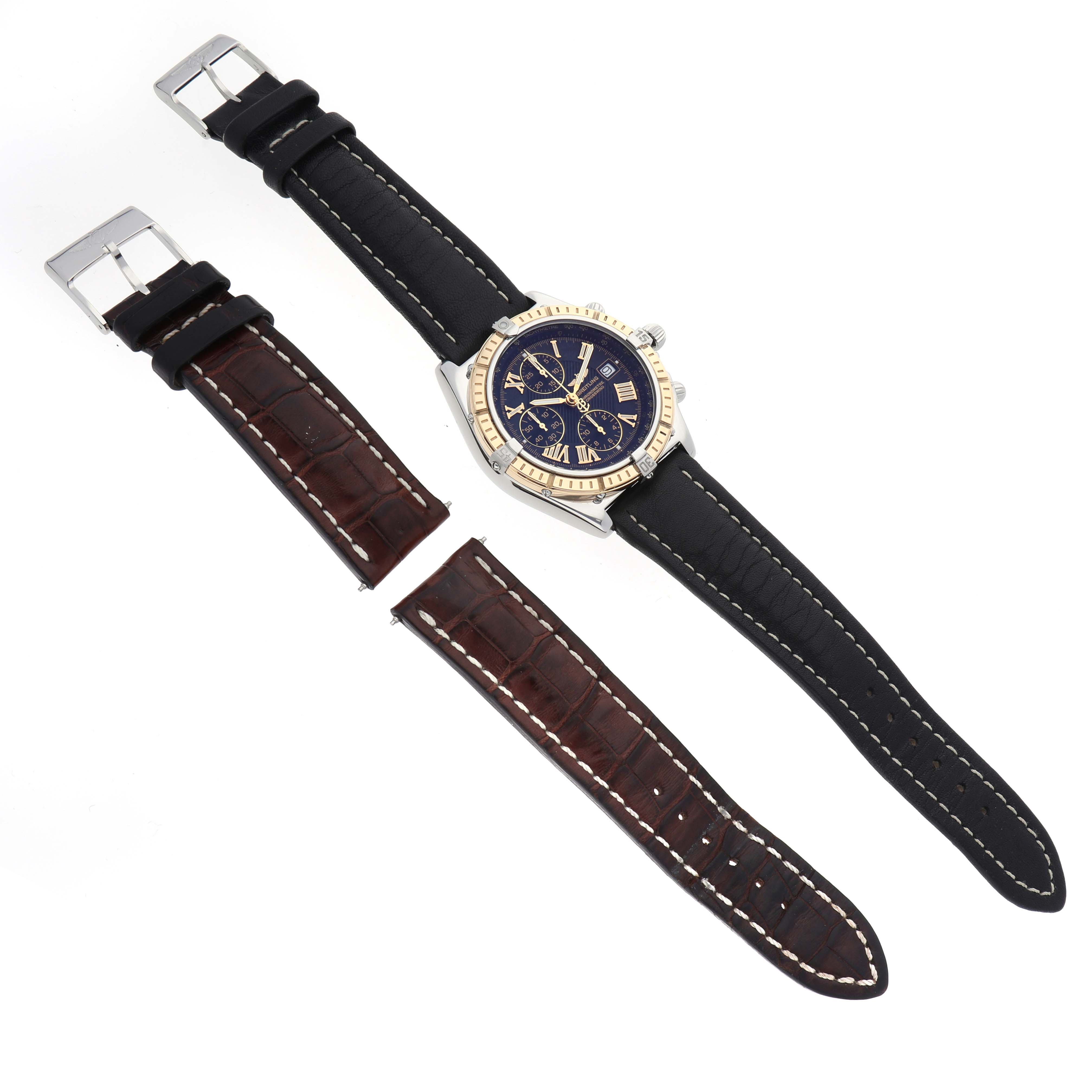The image shows a Breitling Windrider D1335512 Men
s Steel and Gold (two tone) Black Dial D1335512 Men
s Steel and Gold (two tone) Black Dial watch with a black strap and an additional brown strap, viewed from above.