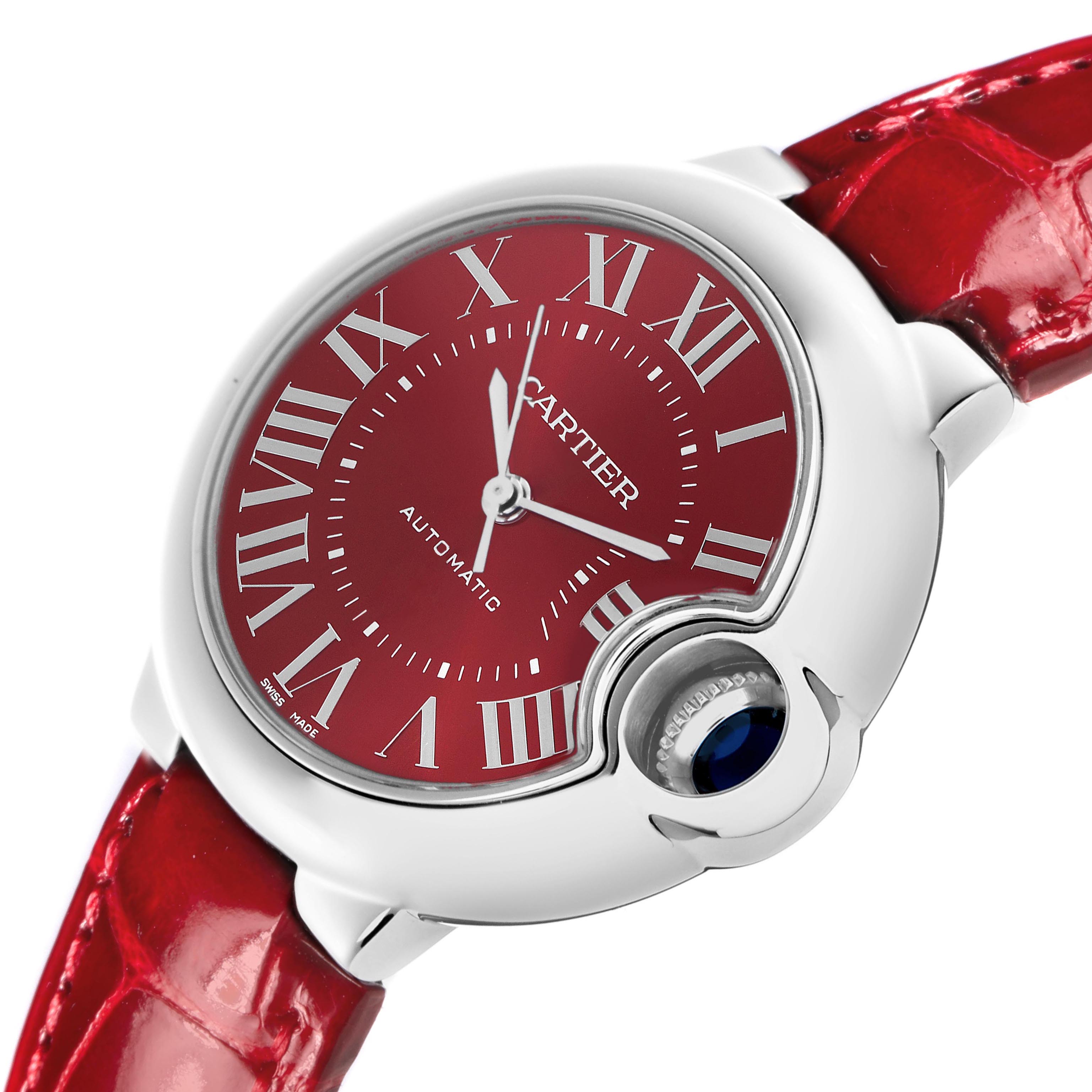 The Cartier Ballon Bleu WSBB0022 Women
s Stainless Steel Red Dial WSBB0022 Women
s Stainless Steel Red Dial watch is shown at an angle highlighting the red dial, crown, and strap.