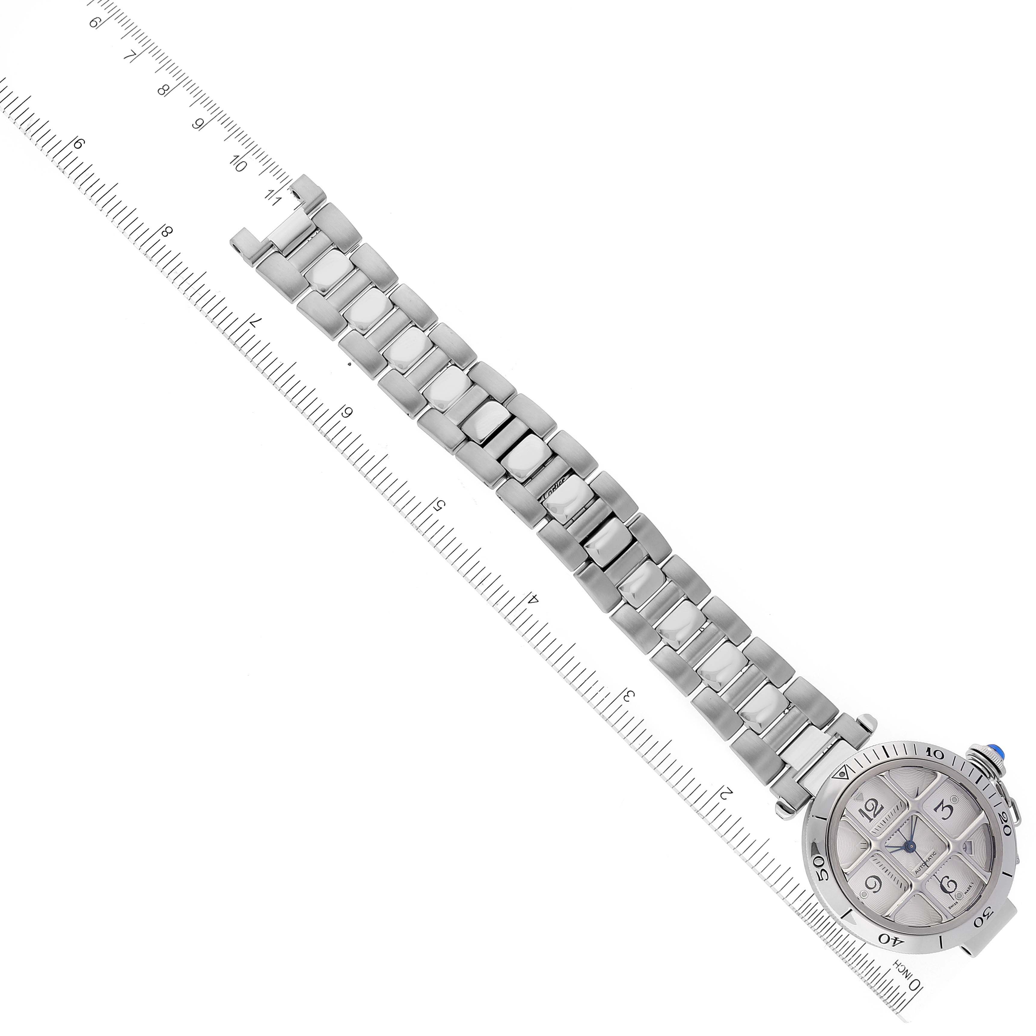 This image shows the entire length and face of a Cartier Pasha W31040H3 Men's Stainless Steel Silver Dial W31040H3 Men's Stainless Steel Silver Dial watch, with its metal bracelet laid along a ruler.