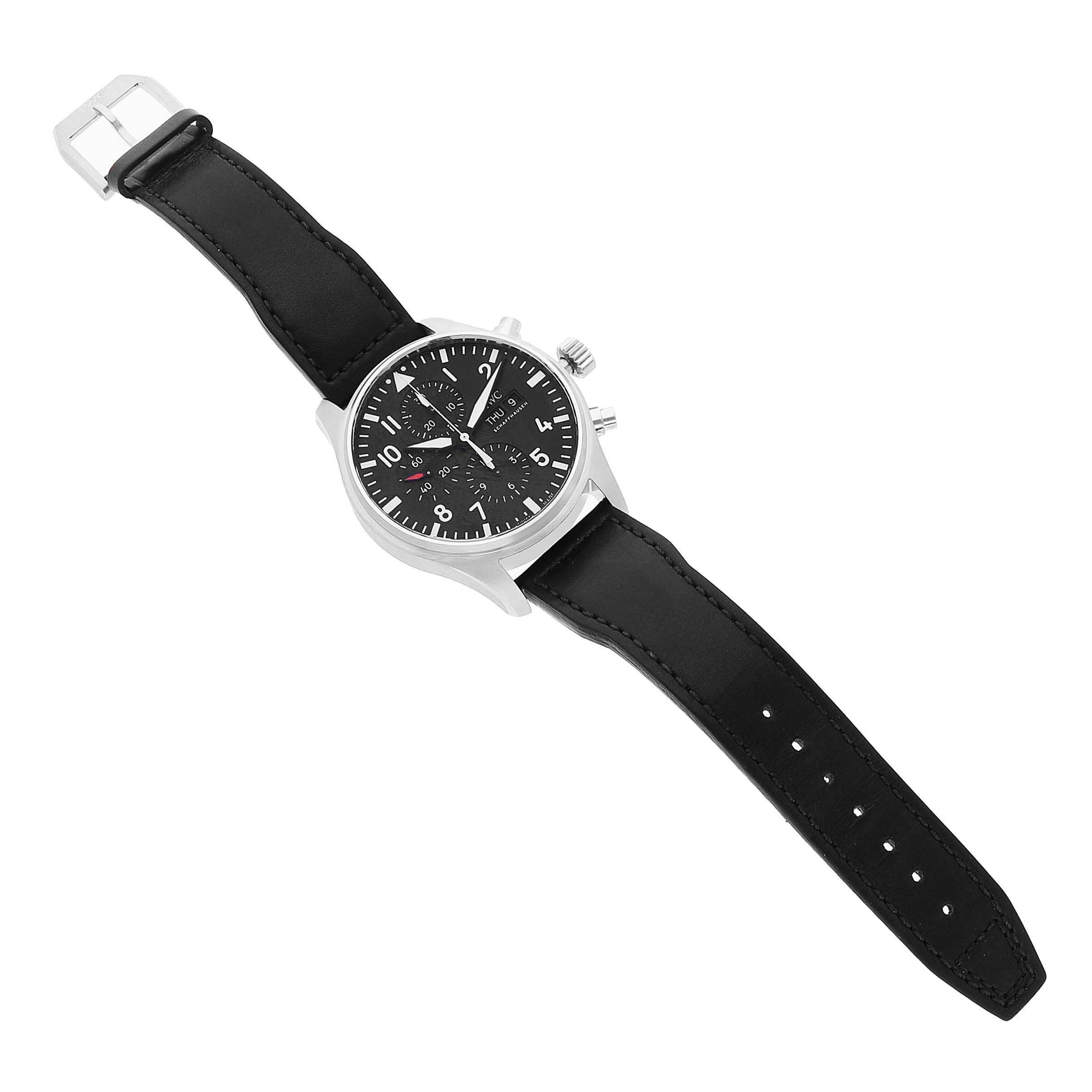 The IWC Pilot IW377710 Men's Stainless Steel Black Dial model watch is shown at an overhead angle, displaying the dial, case, crown, pushers, and full leather strap.