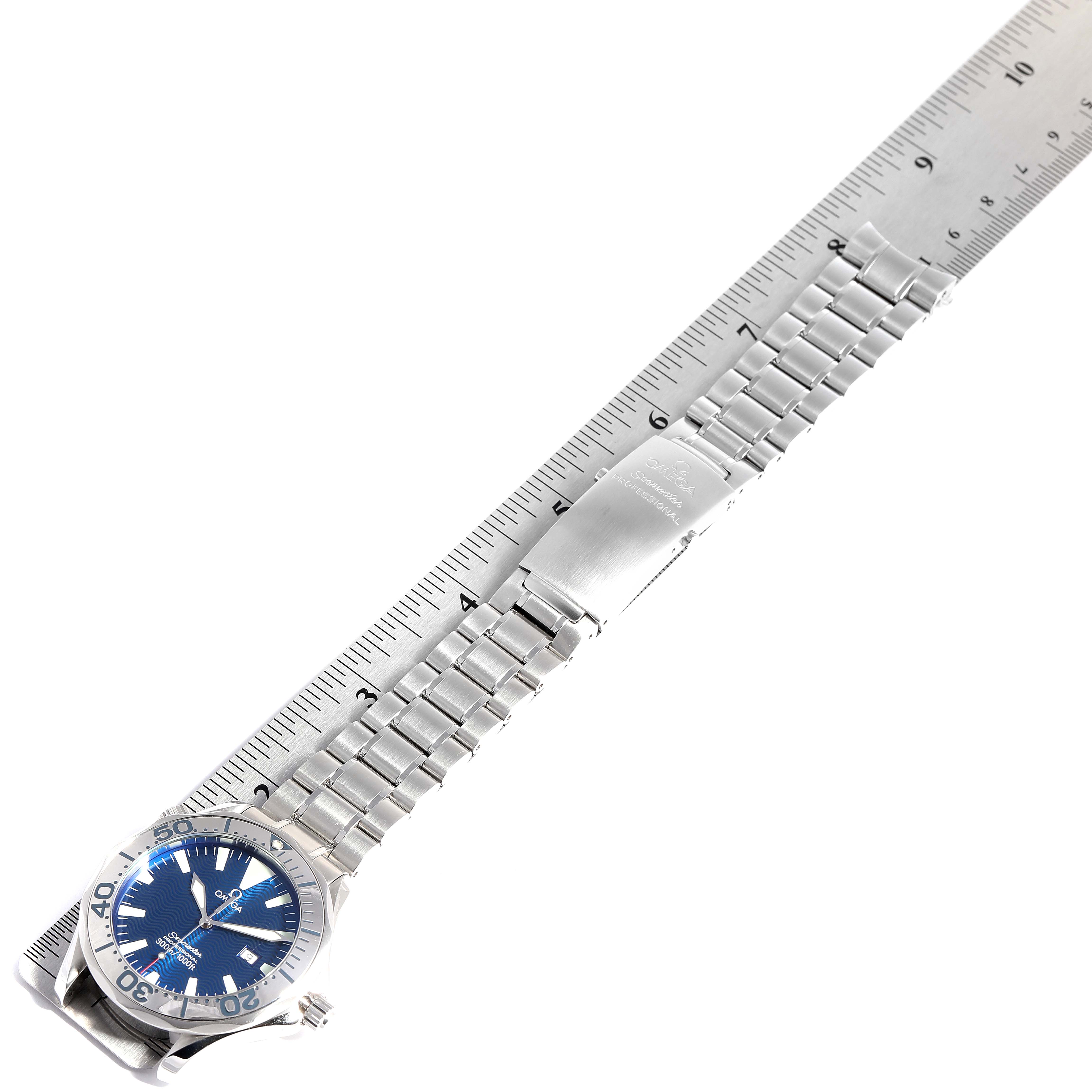 The Omega Seamaster 2265.80.00 Men
s Stainless Steel Blue Dial 2265.80.00 Men
s Stainless Steel Blue Dial watch is displayed at an angle showing the entire bracelet and clasp against a ruler for measurement.