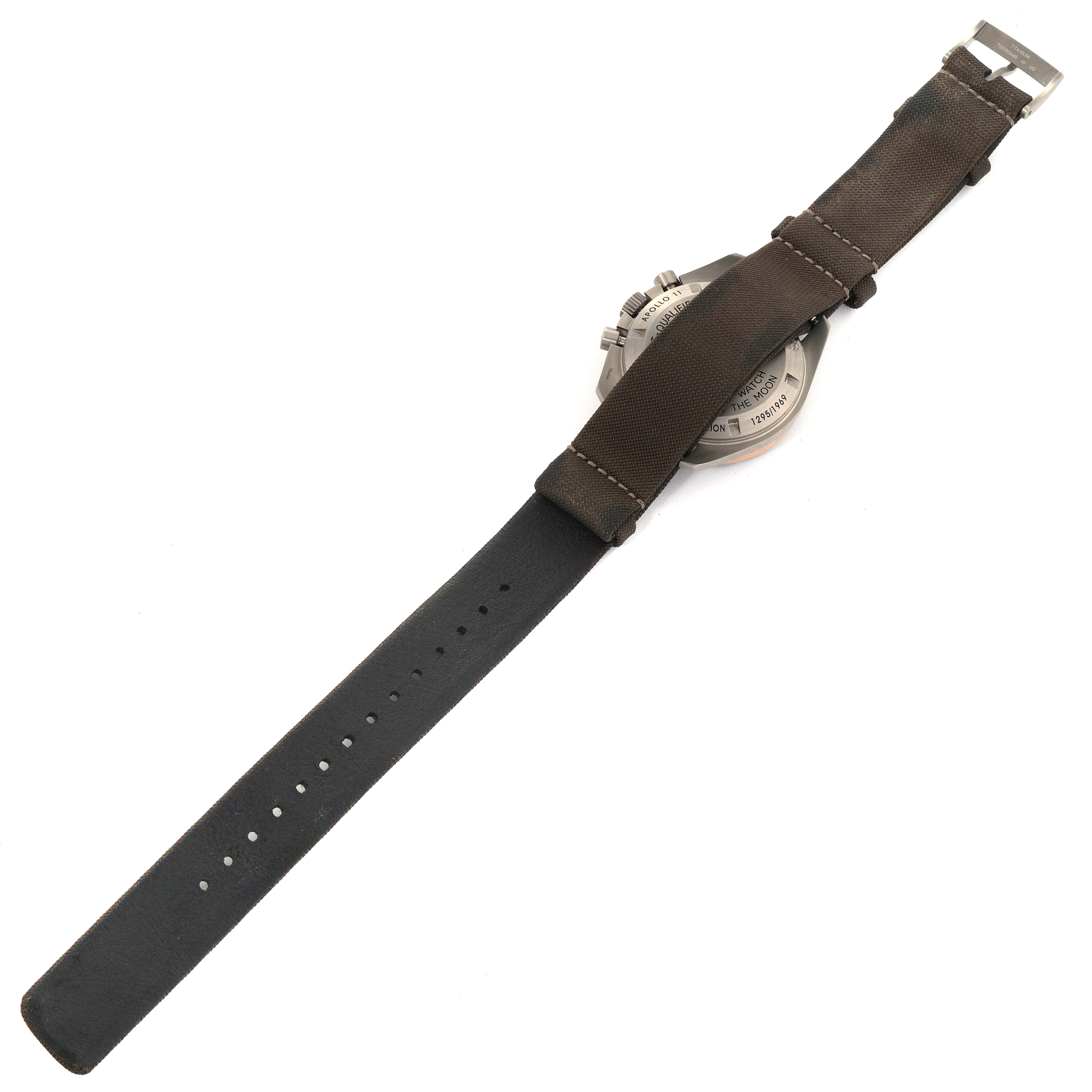 The image shows the back side of an Omega Speedmaster 311.62.42.30.06.001 Men's Titanium Grey Dial 311.62.42.30.06.001 Men's Titanium Grey Dial watch, highlighting the case back and leather strap.