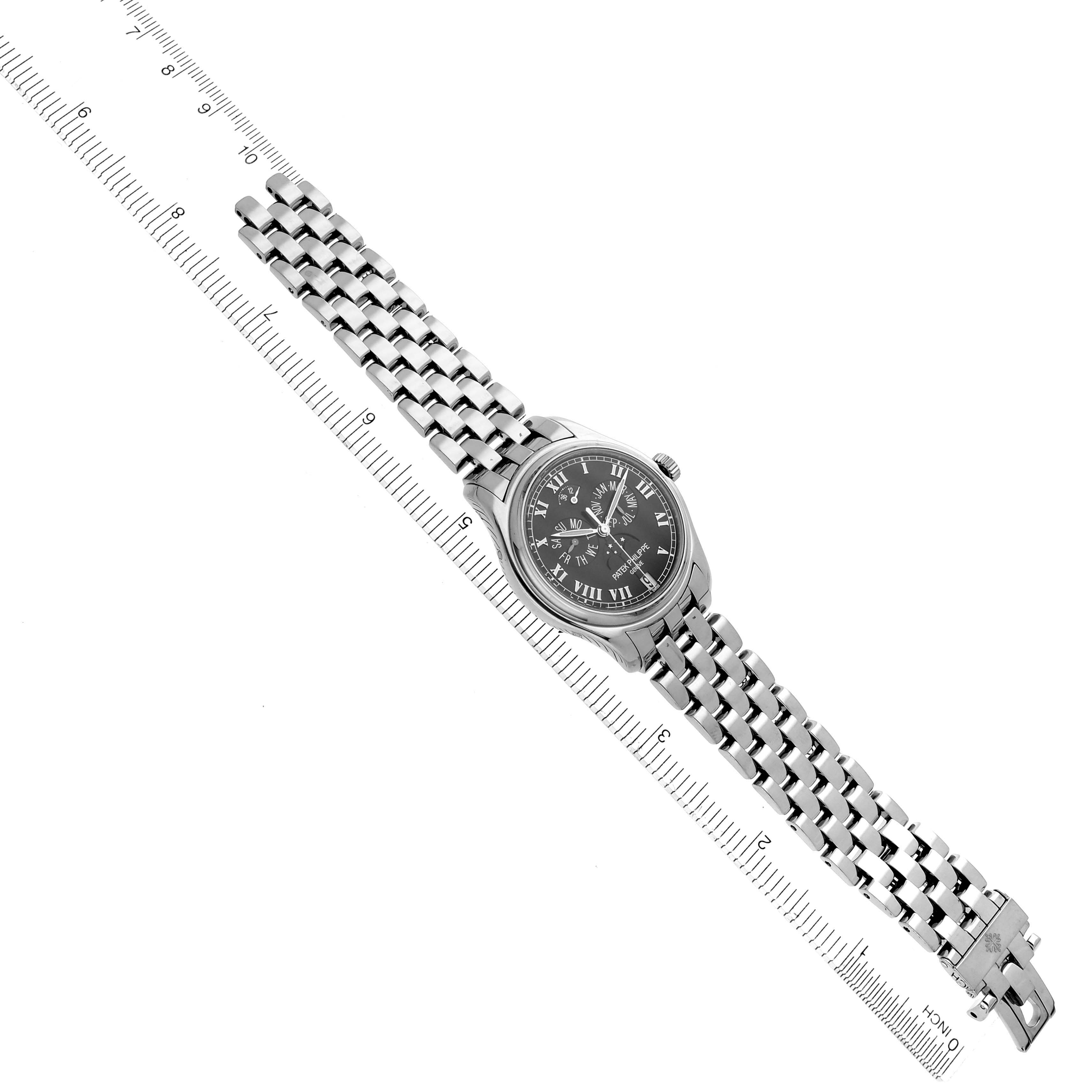 The Patek Philippe Complications 5036/1G Men
s White Gold Black Dial 5036/1G Men
s White Gold Black Dial watch is shown diagonally, displaying its dial, bracelet, and crown alongside a measuring ruler.