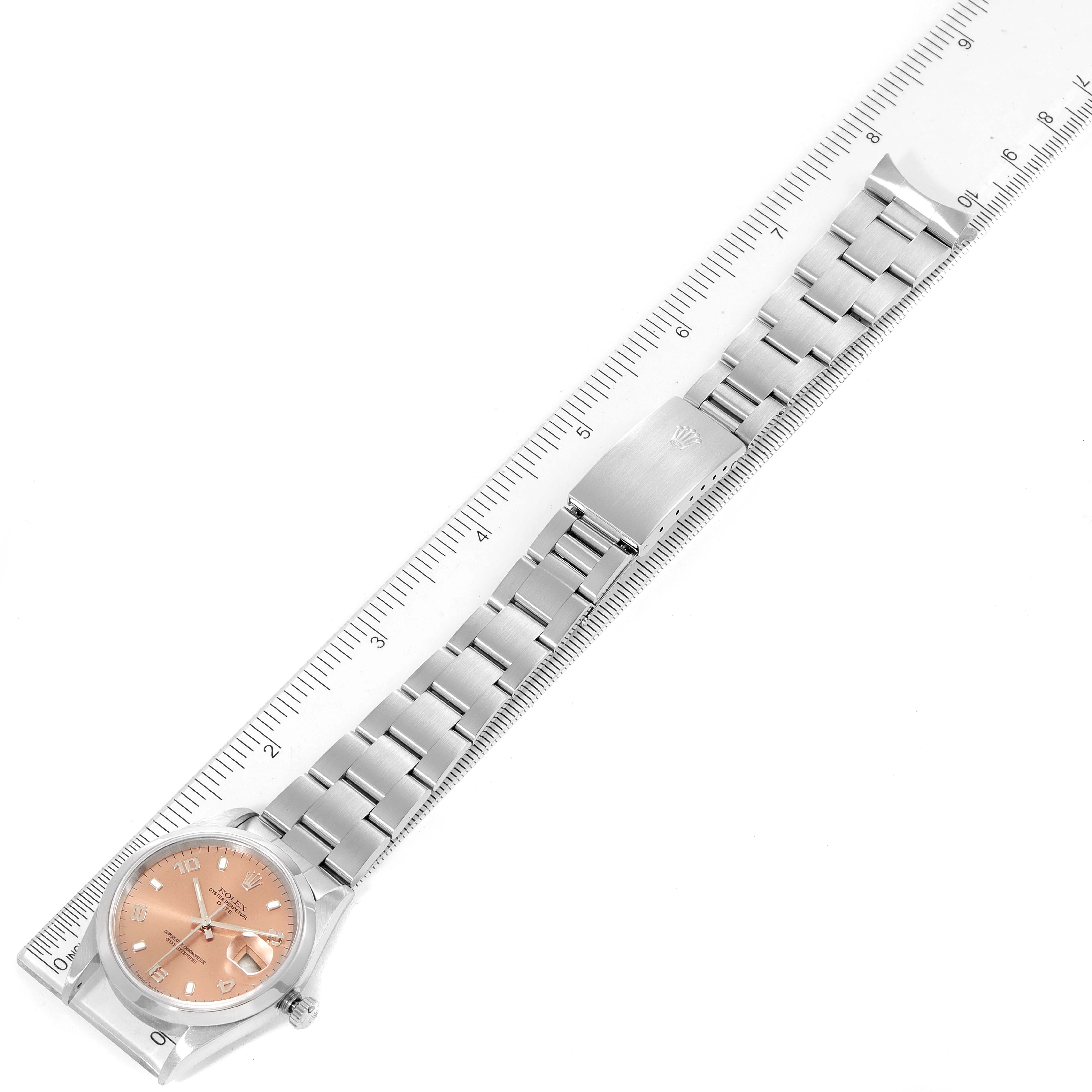 The image shows a Rolex Date 15200 Men's Stainless Steel Pink Dial 15200 Men's Stainless Steel Pink Dial model watch positioned next to a ruler, displaying the dial, bracelet, and clasp.