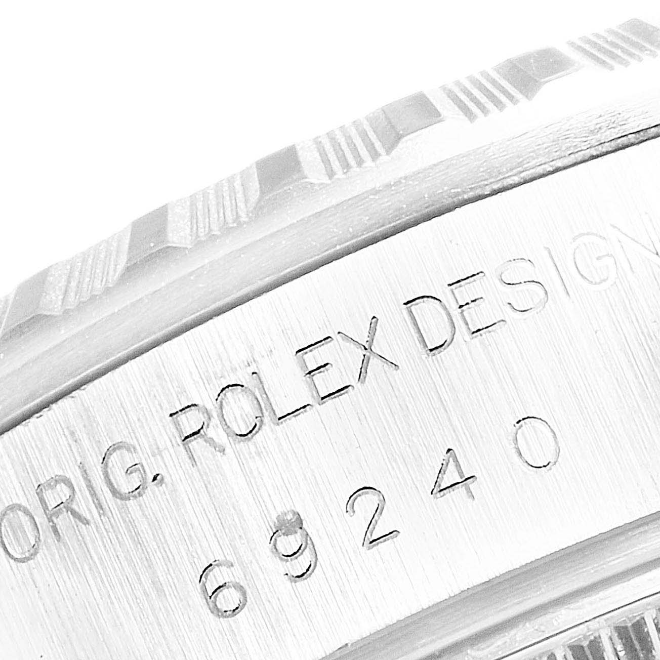 The image shows a close-up of the Rolex Datejust 69240  Women
s Stainless Steel Silver Dial 69240  Women
s Stainless Steel Silver Dial model
s bezel and engraved serial number on the watch case.