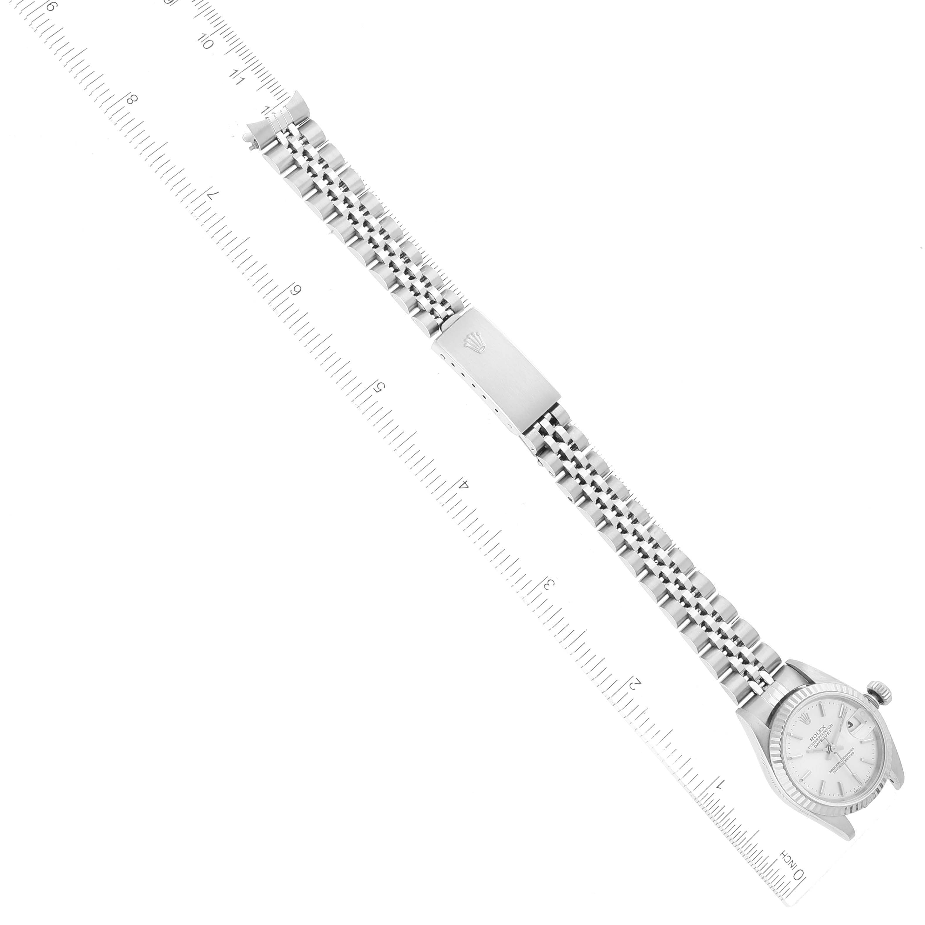 This image shows a Rolex Datejust 79174 Women's Stainless Steel Silver Dial 79174 Women's Stainless Steel Silver Dial watch laid flat with a clear view of its face, bracelet, and clasp against a ruler.