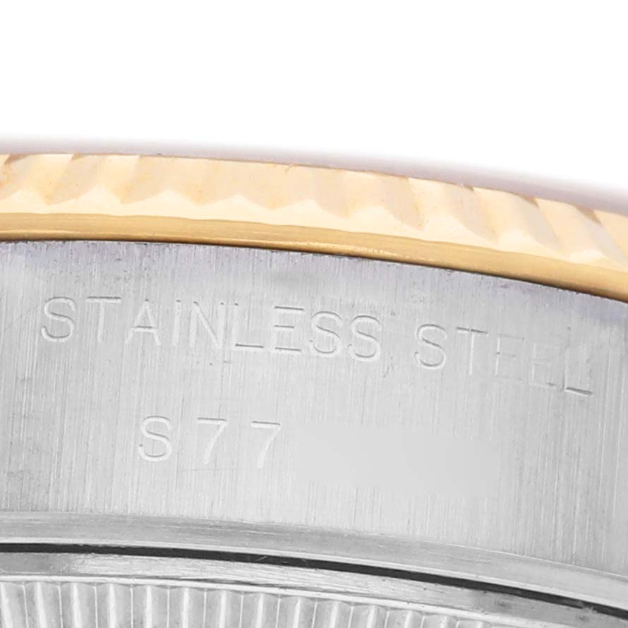The image shows a close-up of the side of a Rolex Datejust 69173 Women's Steel and Gold (two tone) Champagne Dial watch, highlighting the stainless steel engraving and bezel.