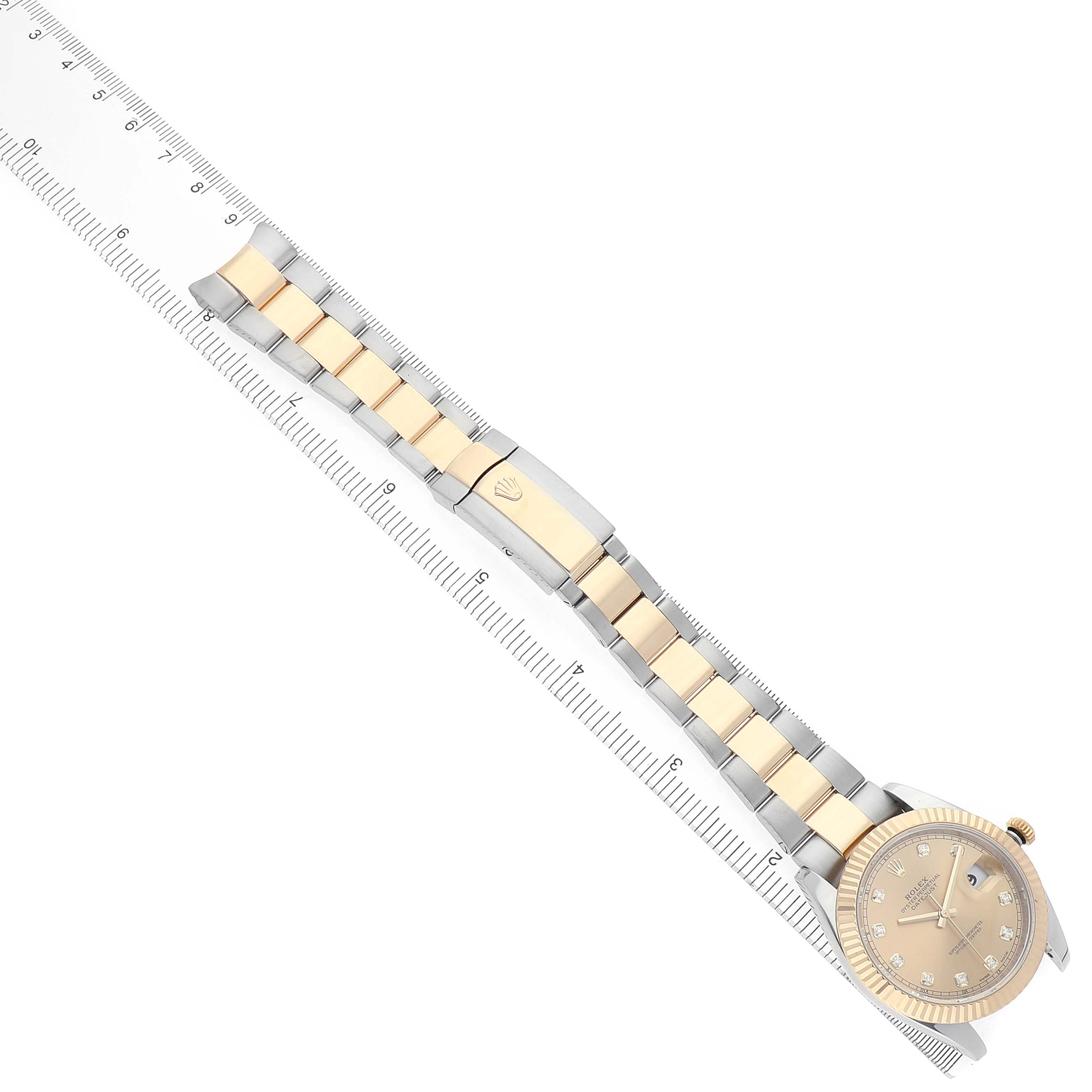 The Rolex Datejust 41 M126333-0011 Men's Steel and Gold (two tone) Champagne Dial is shown diagonally with its bracelet extended next to a ruler, displaying the watch face and clasp.