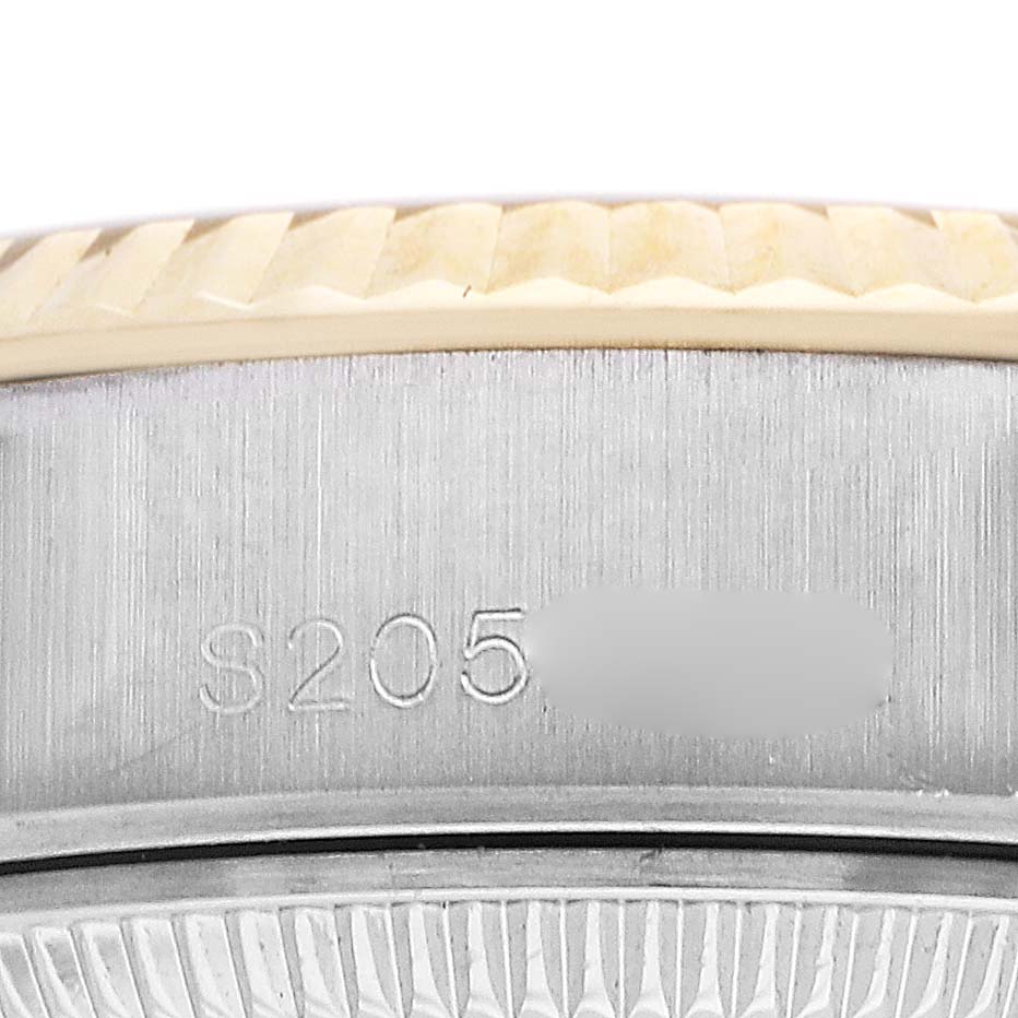 The image shows a close-up of the Rolex Datejust 69173 Women
s Steel and Gold (two tone) Champagne Dial 69173 Women
s Steel and Gold (two tone) Champagne Dial
s bezel and part of the serial number on the side.