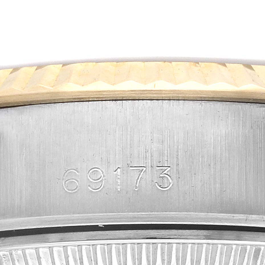 The image shows a close-up of the side of a Rolex Datejust 69173 Women
s Steel and Gold (two tone) Champagne Dial 69173 Women
s Steel and Gold (two tone) Champagne Dial case, highlighting the serial number engraving.